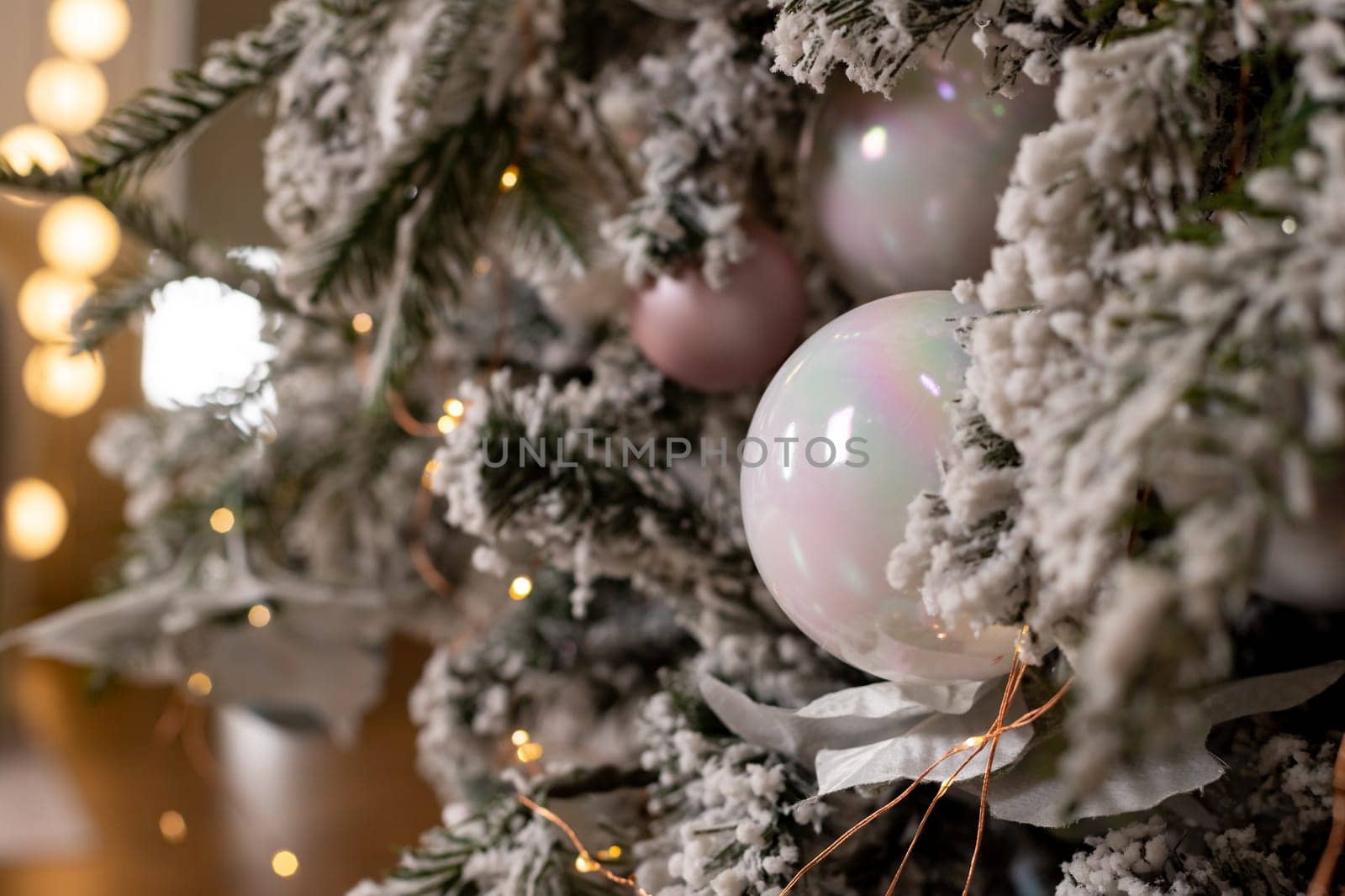 Christmas holiday composition. Christmas tree fir branches, silver balls on top border on pink pastel background with copy space.
