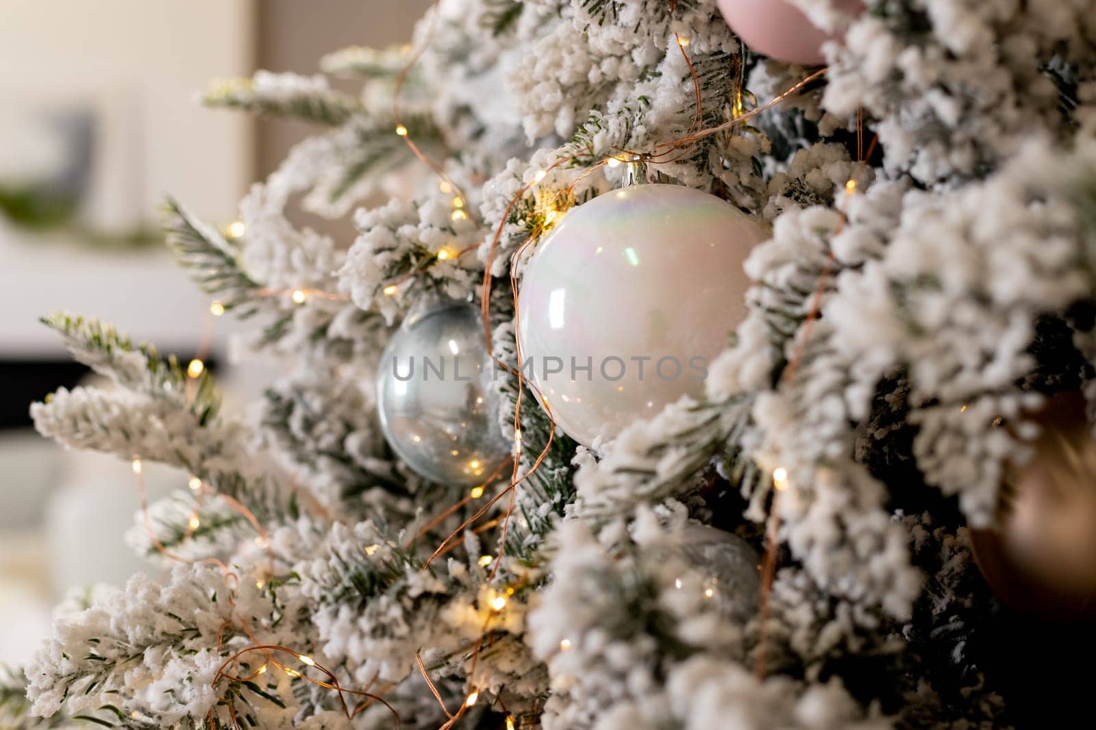 Christmas holiday composition. Christmas tree fir branches, silver balls on top border on pink pastel background with copy space.