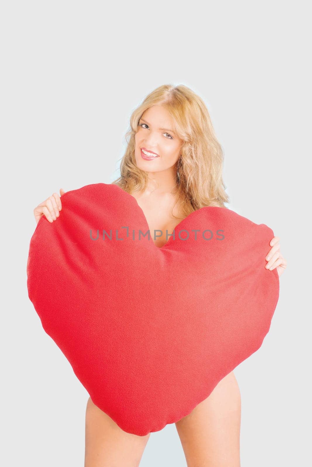beautiful woman holding heart shaped cushion