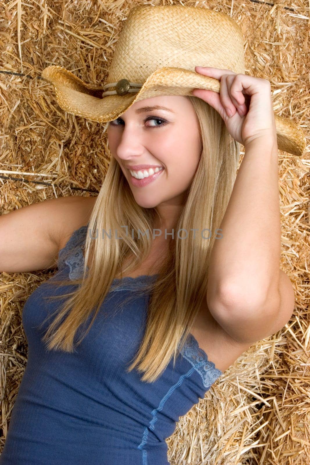 Smiling blond cowgirl woman wearing hat