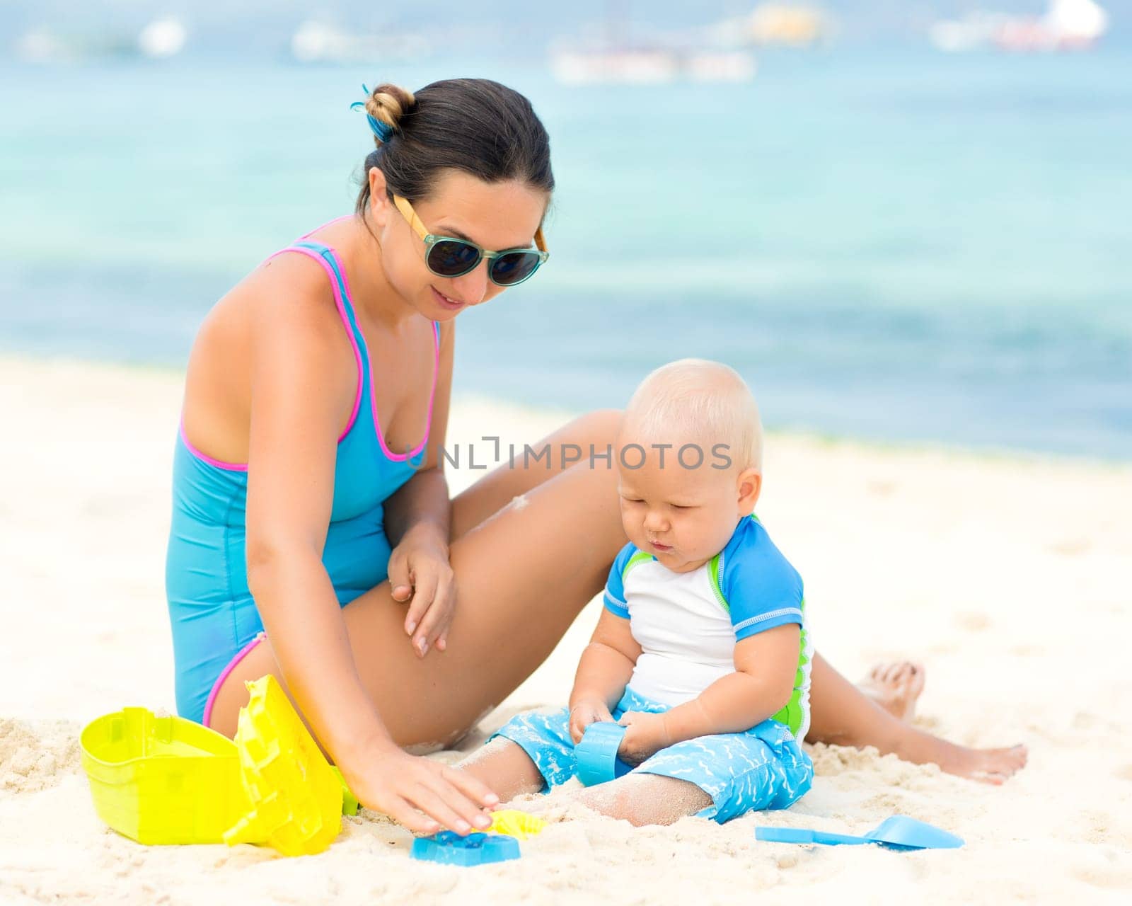 Baby and mom are playing beach toys