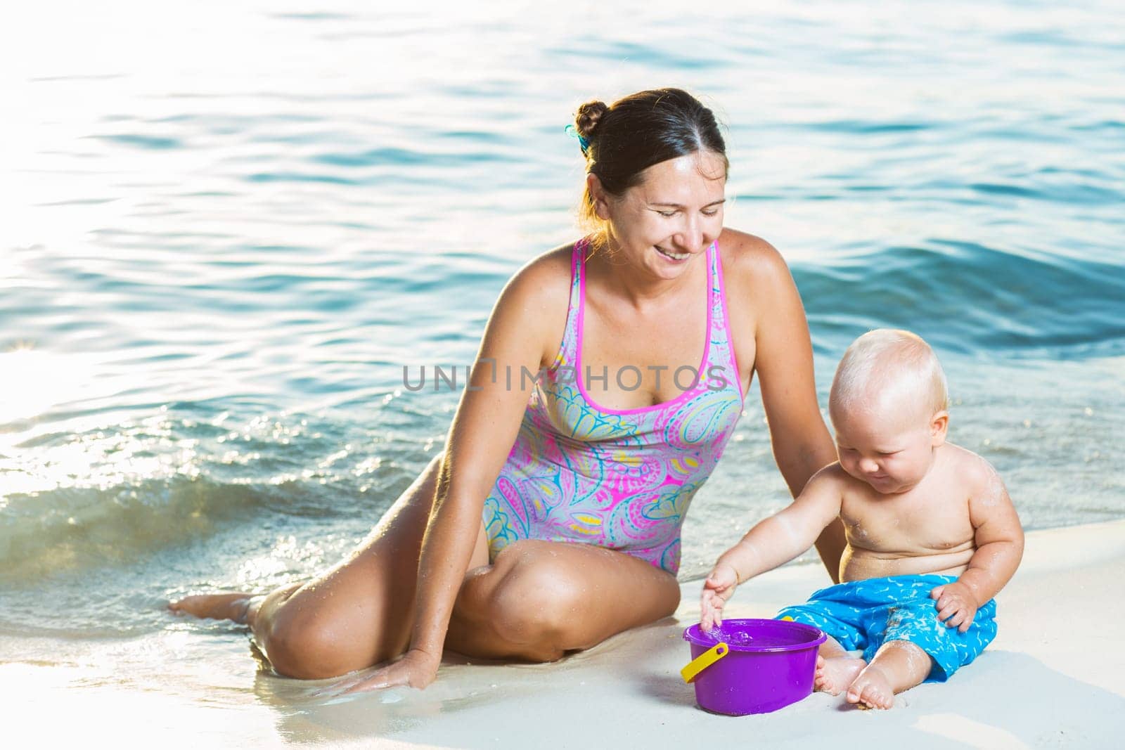 Baby and mom are playing beach toys