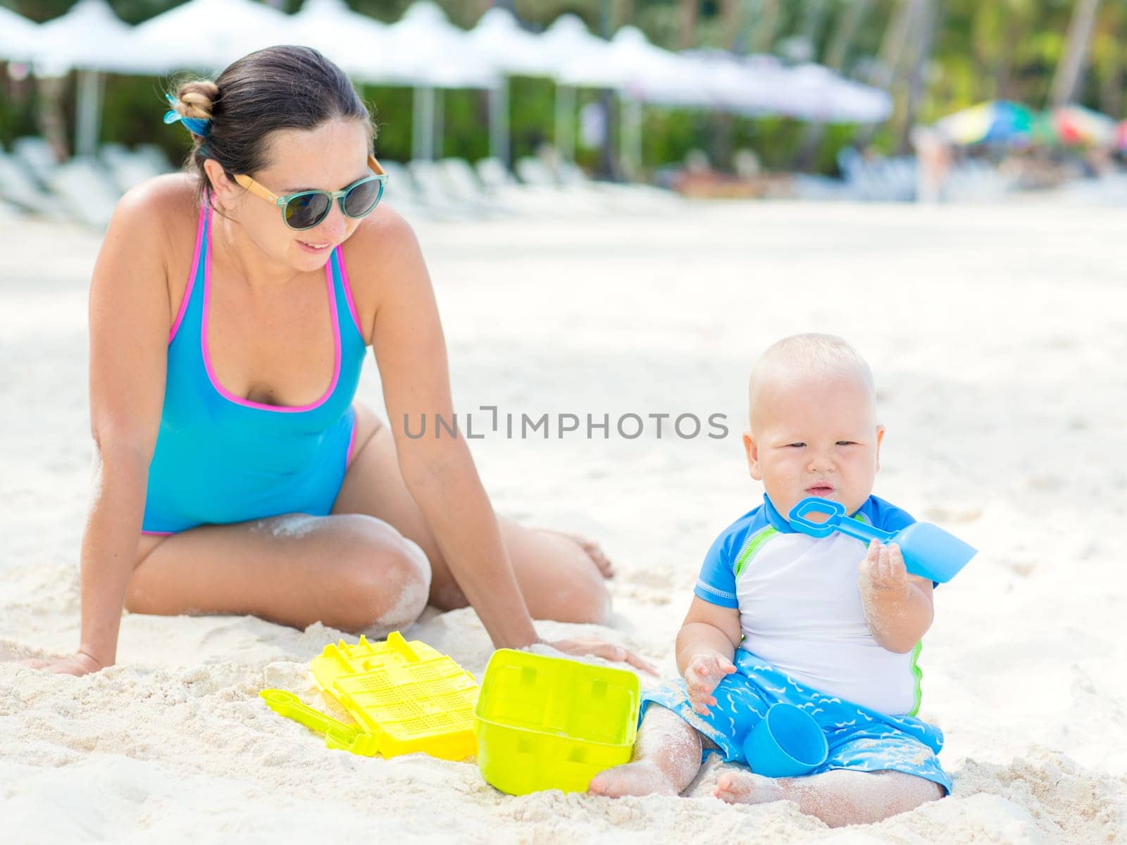 Baby and mom are playing beach toys