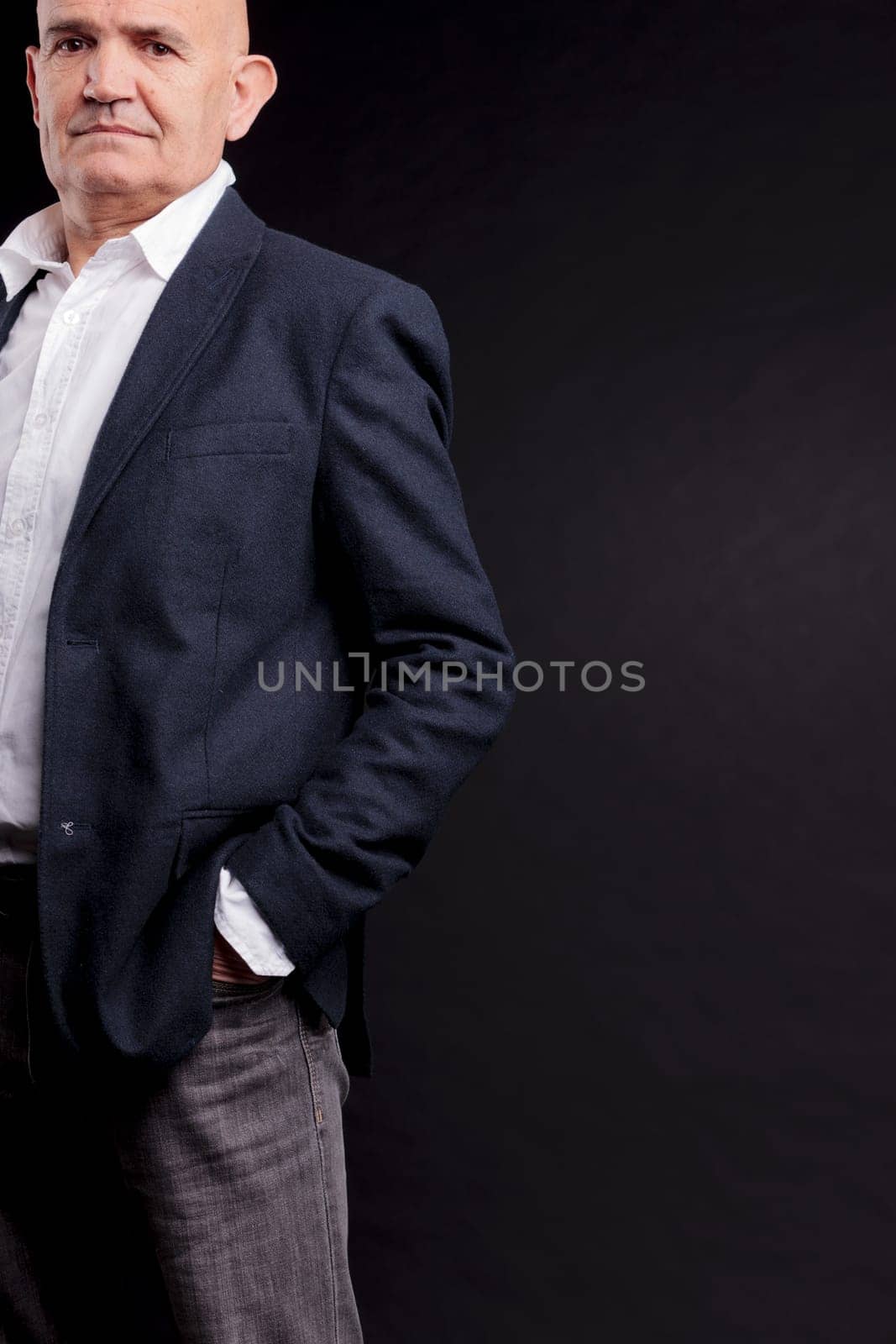 old bald self-confident businessman on a dark background