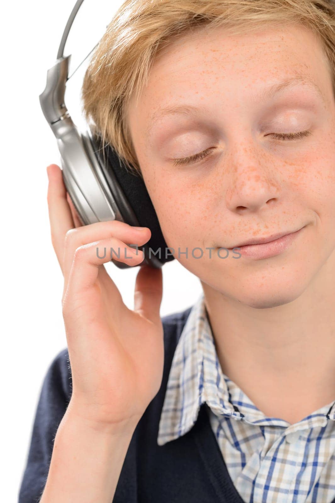 Teenage boy with eyes closed enjoying music over white background