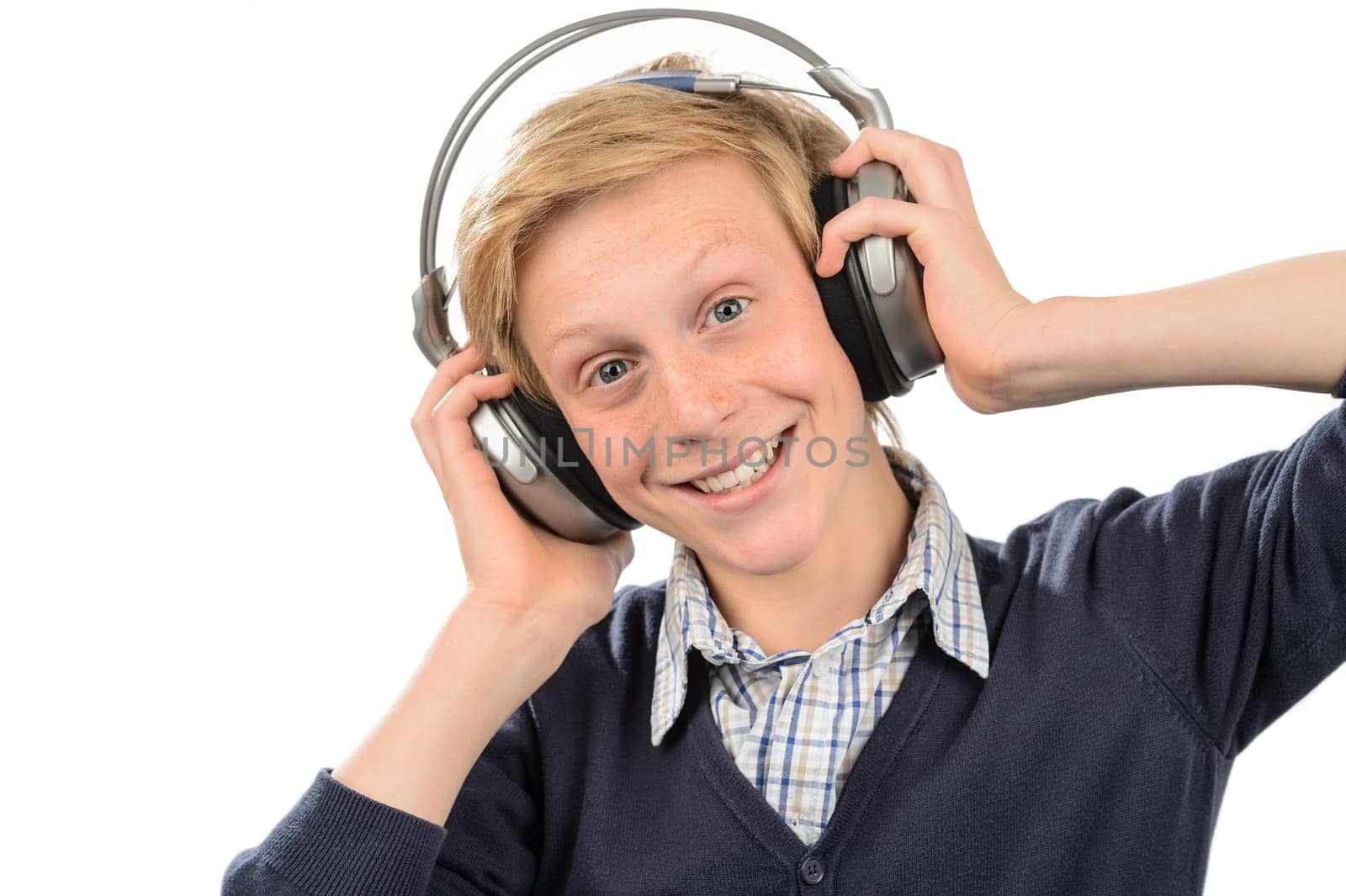 Happy teenage boy listening to music against white background