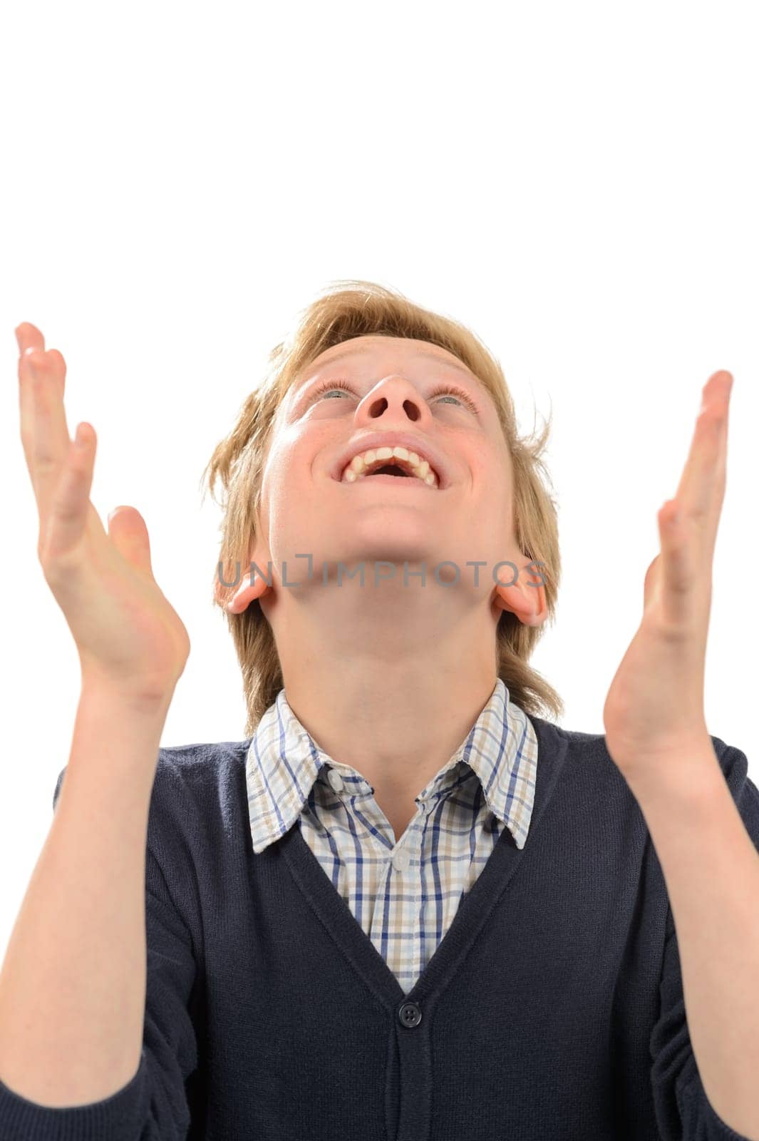 Happy teenage boy looking up while praying isolated on white