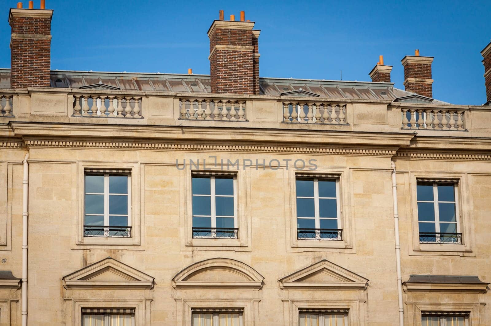 Exterior view of a Parisian townhouse in summer in front of a blue sky
