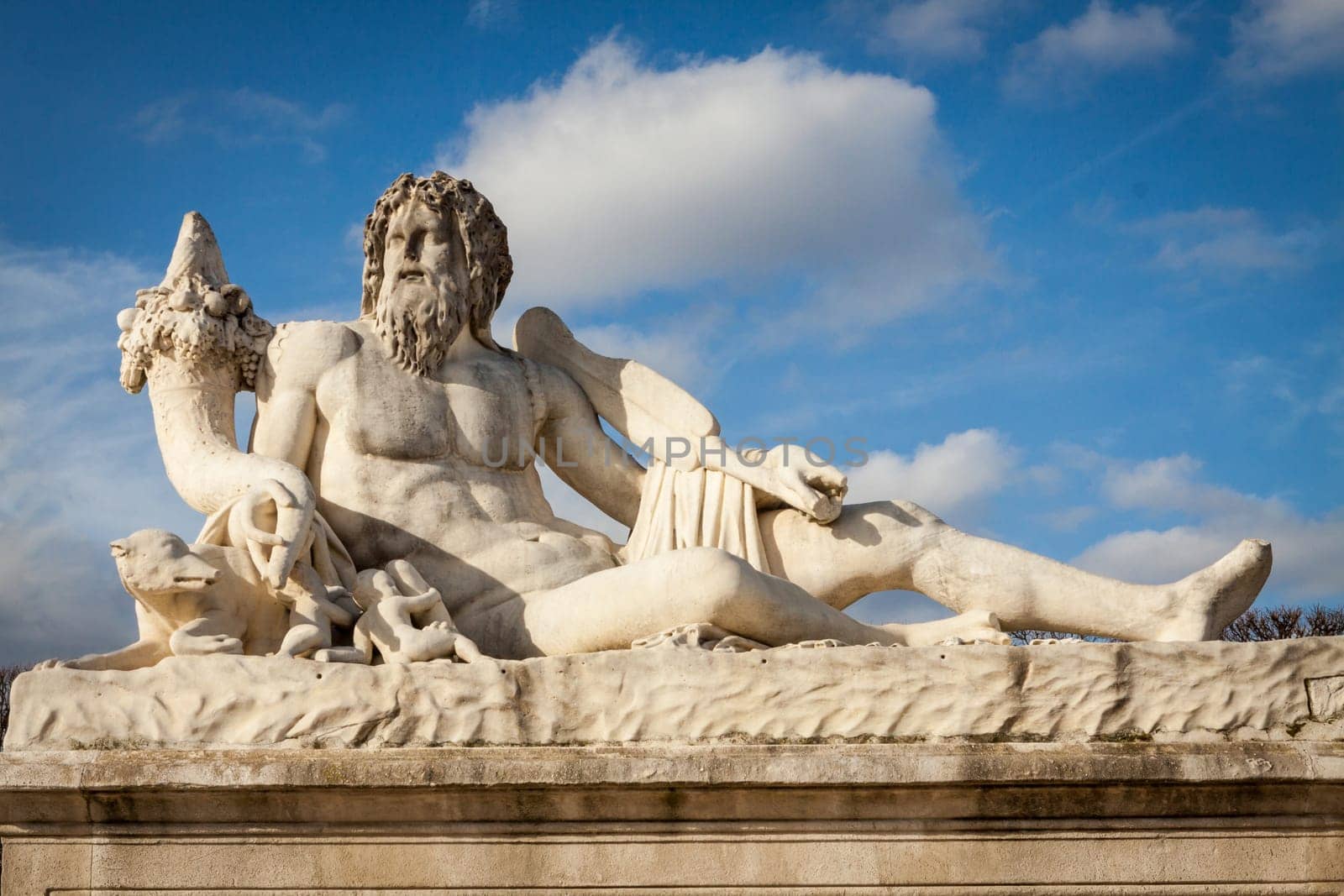 Statue of stone marble carved in front of blue sky in Paris