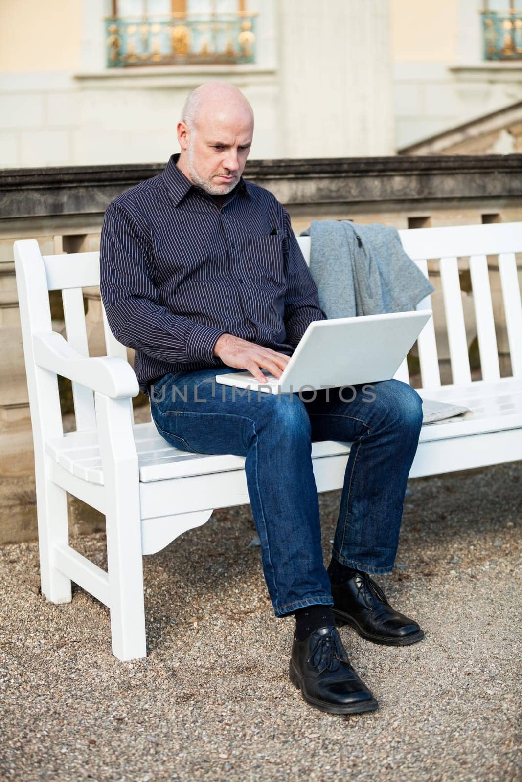 Businessman senior with notebook laptop during lunch break in summer outdoors