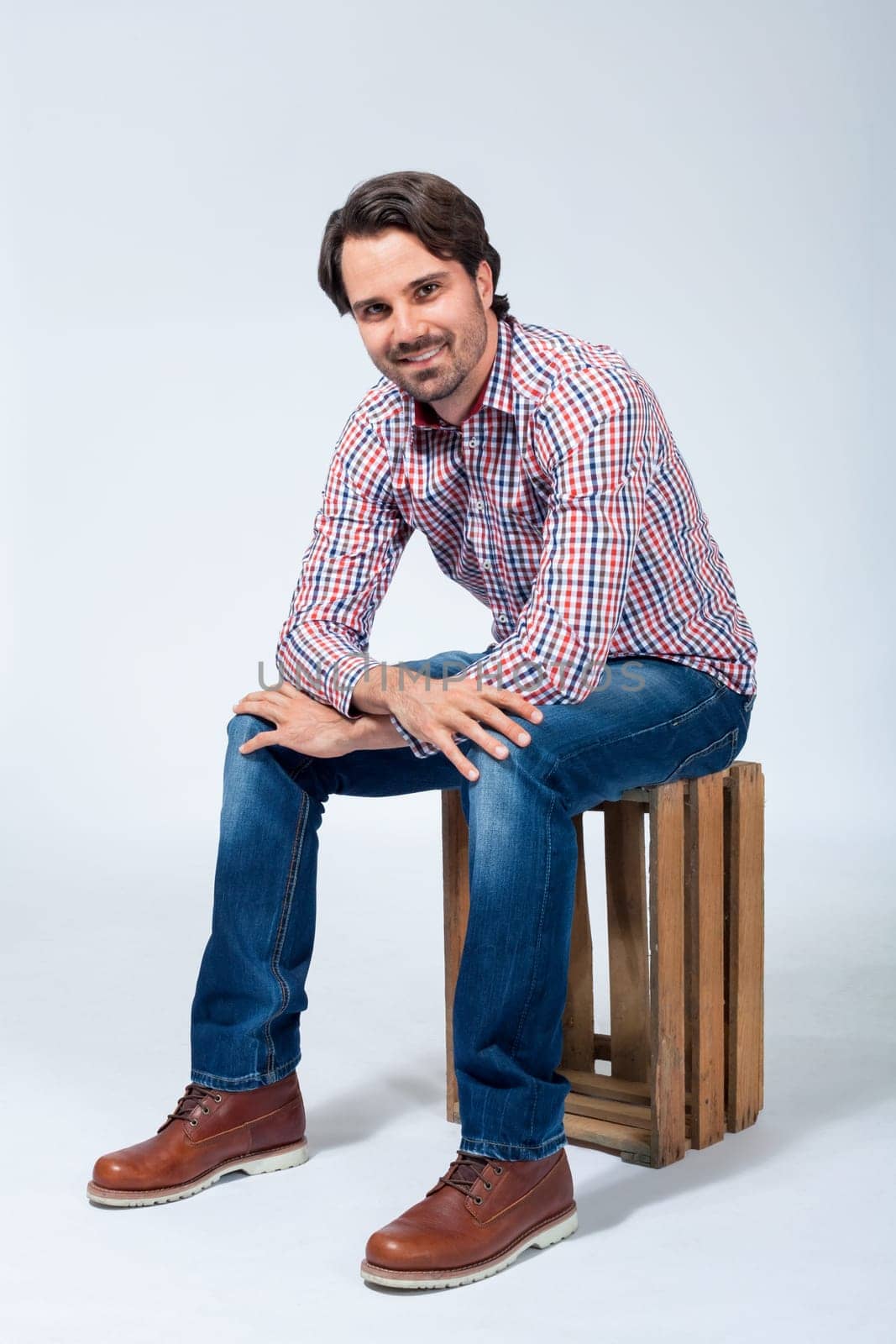 Young man with beard and dark hair with jeans and carated shirt