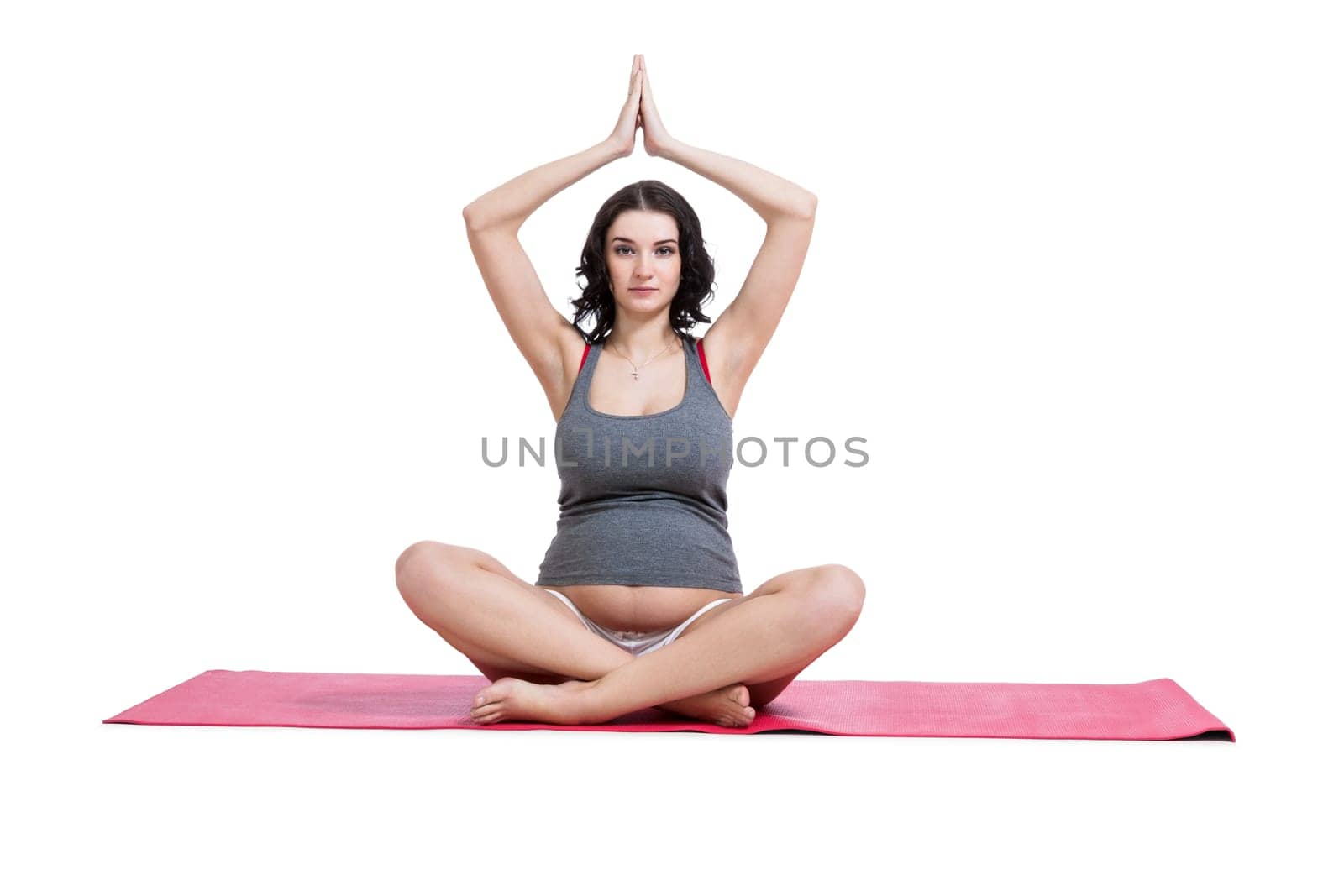Attractive pregnant young woman makes yoga isolated against white background