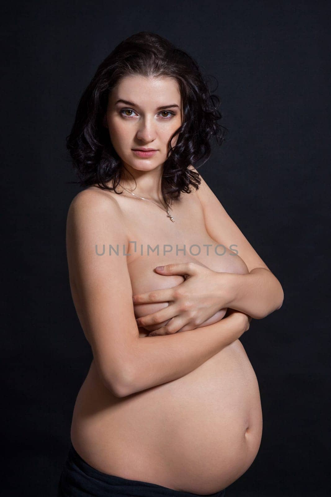 Young pregnant woman with baby belly naked in front of black butt