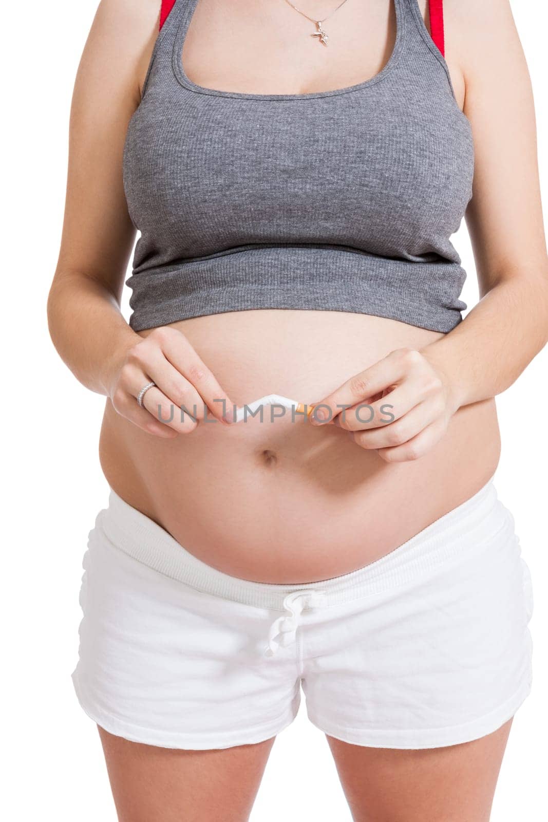 Pregnant woman breaks a cigarette in front of her baby belly isolated against white background