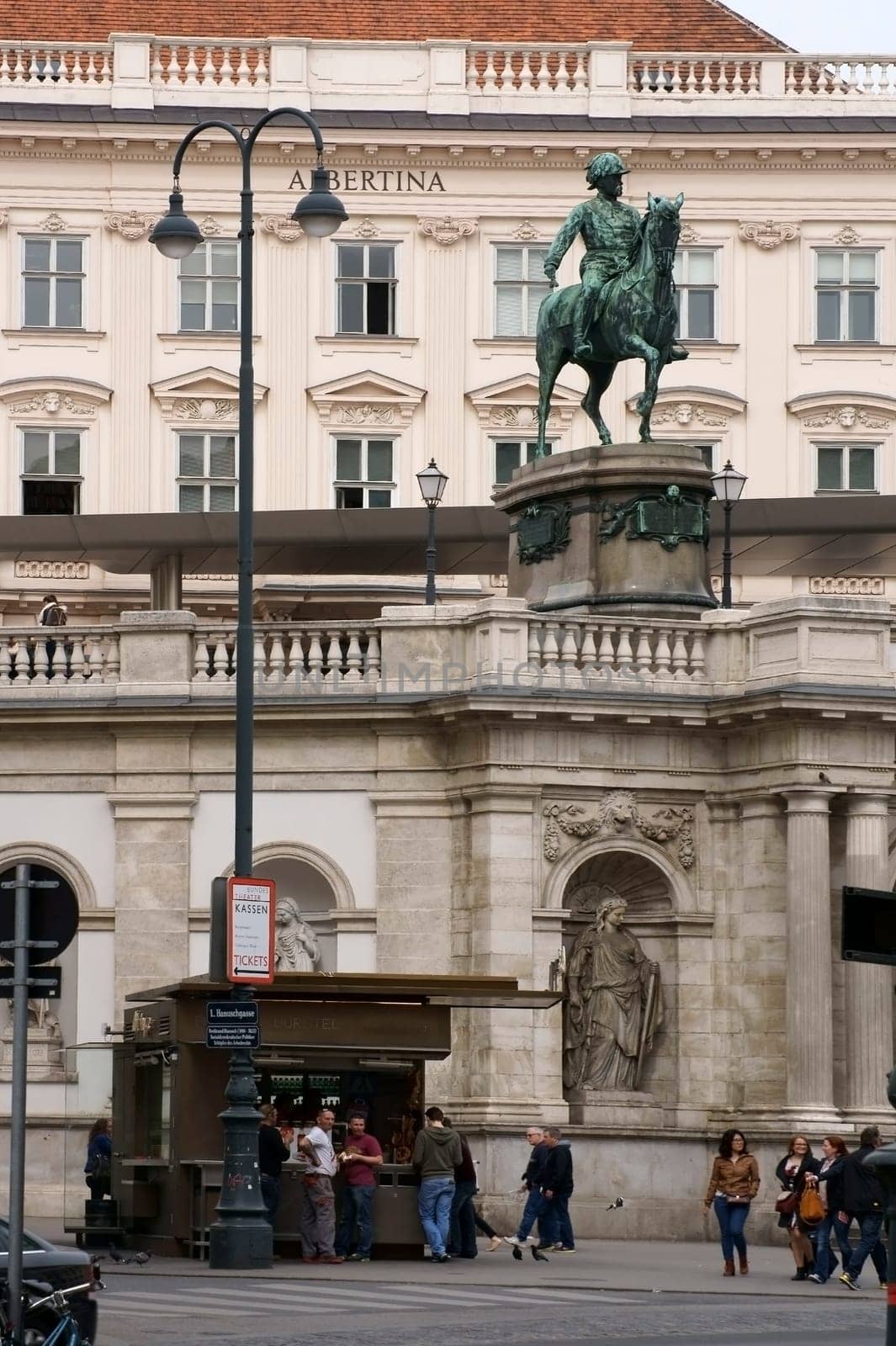 Vienna,Austria - March 31,2014: Locals and tourists stand at a sausage stall under Albrecht's equestrian monument in front of the Albertina Art Museum on March 31,2014 in Vienna.