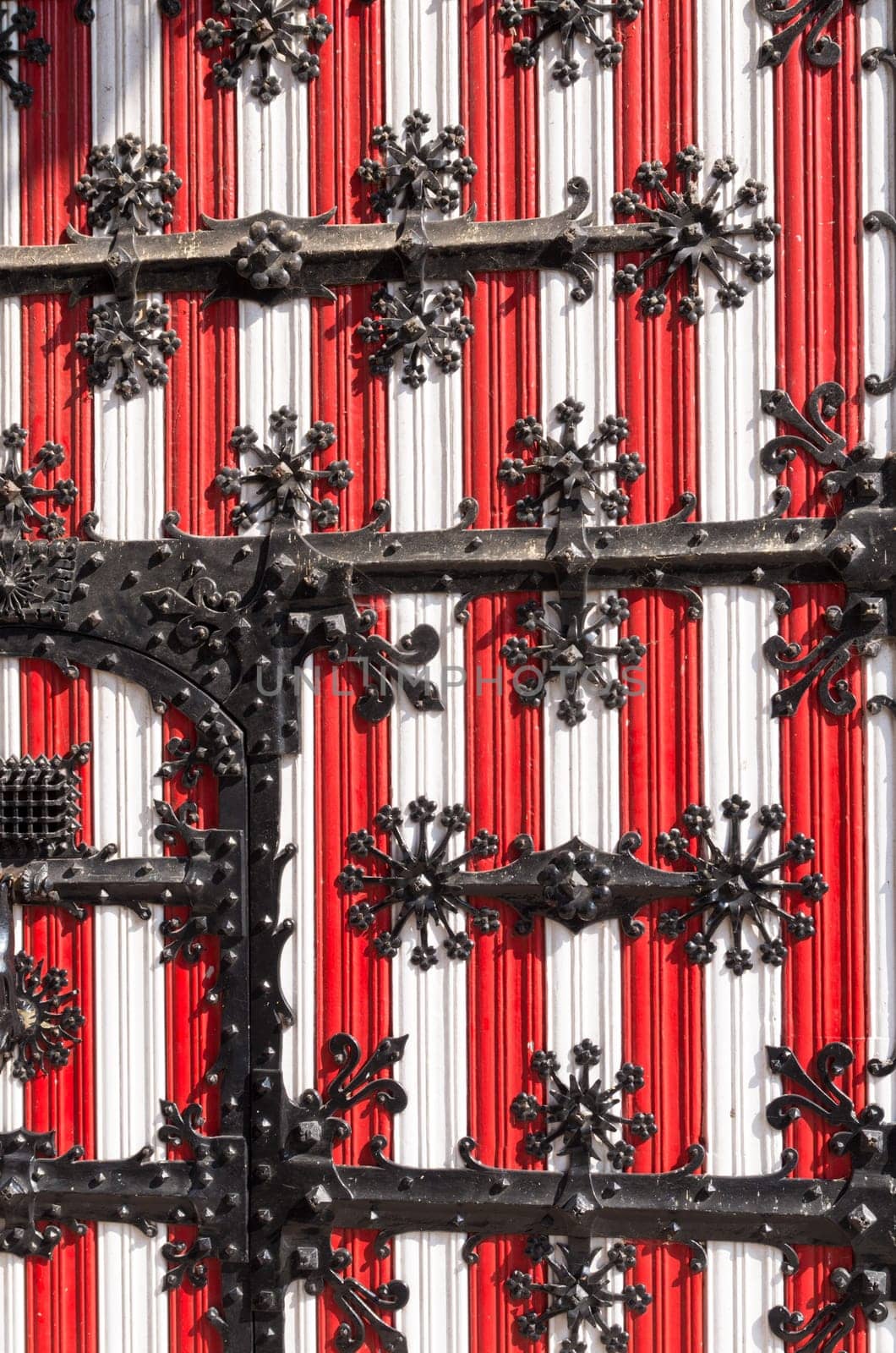 red with white medieval door with metal decorations on it