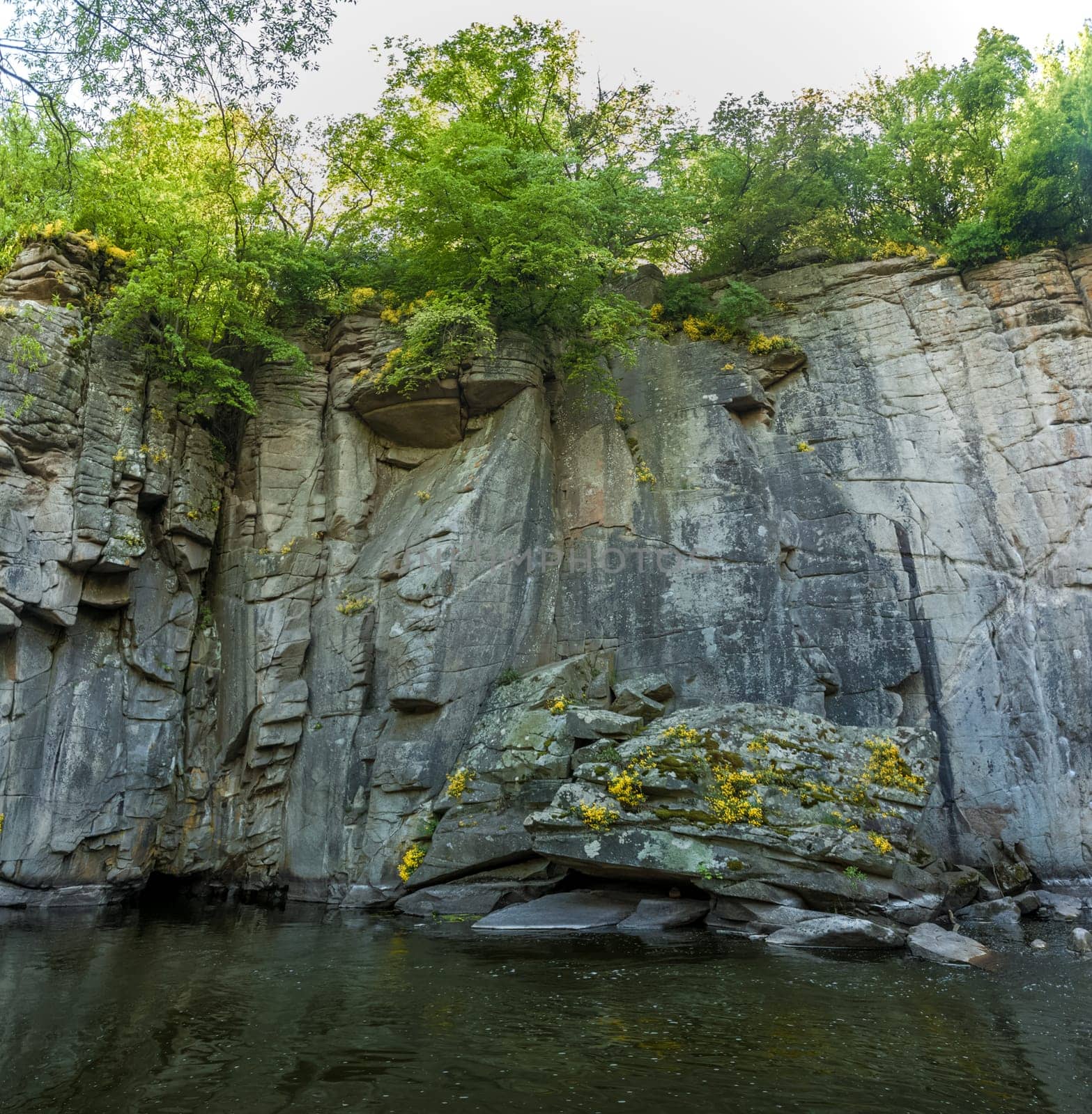 Panoramic photo of high rock wall on mountain river