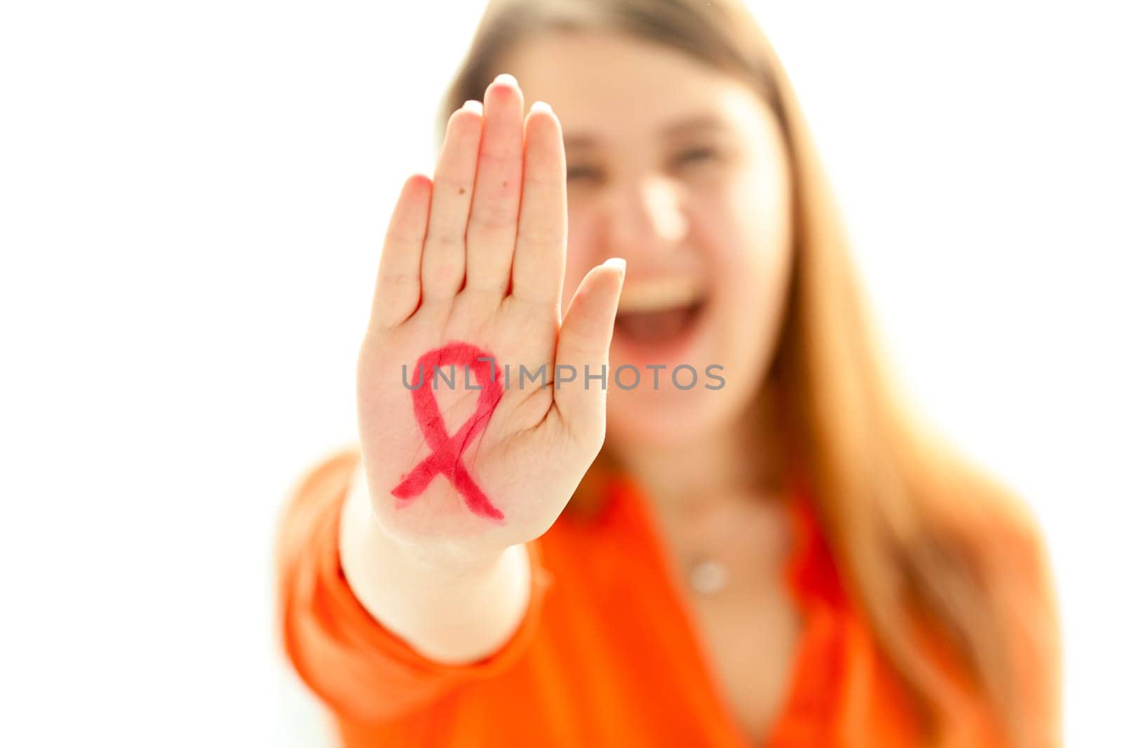 Portrait of young woman showing HIV red loop drawn on hand