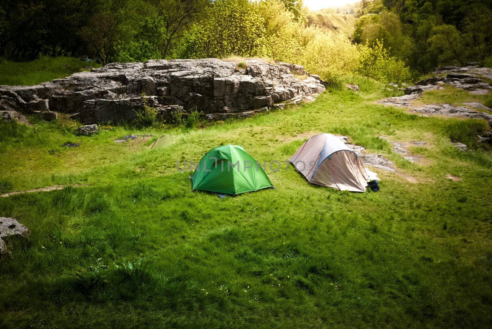 Landscape of beautiful hills with two tourist tents at sunny day