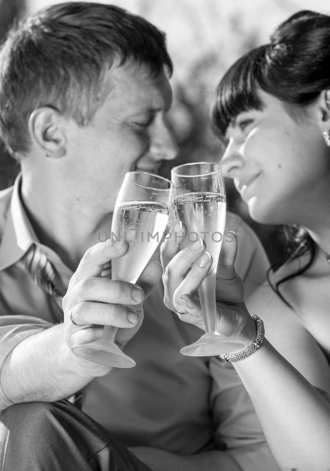 Closeup monochrome portrait of just married couple drinking champagne