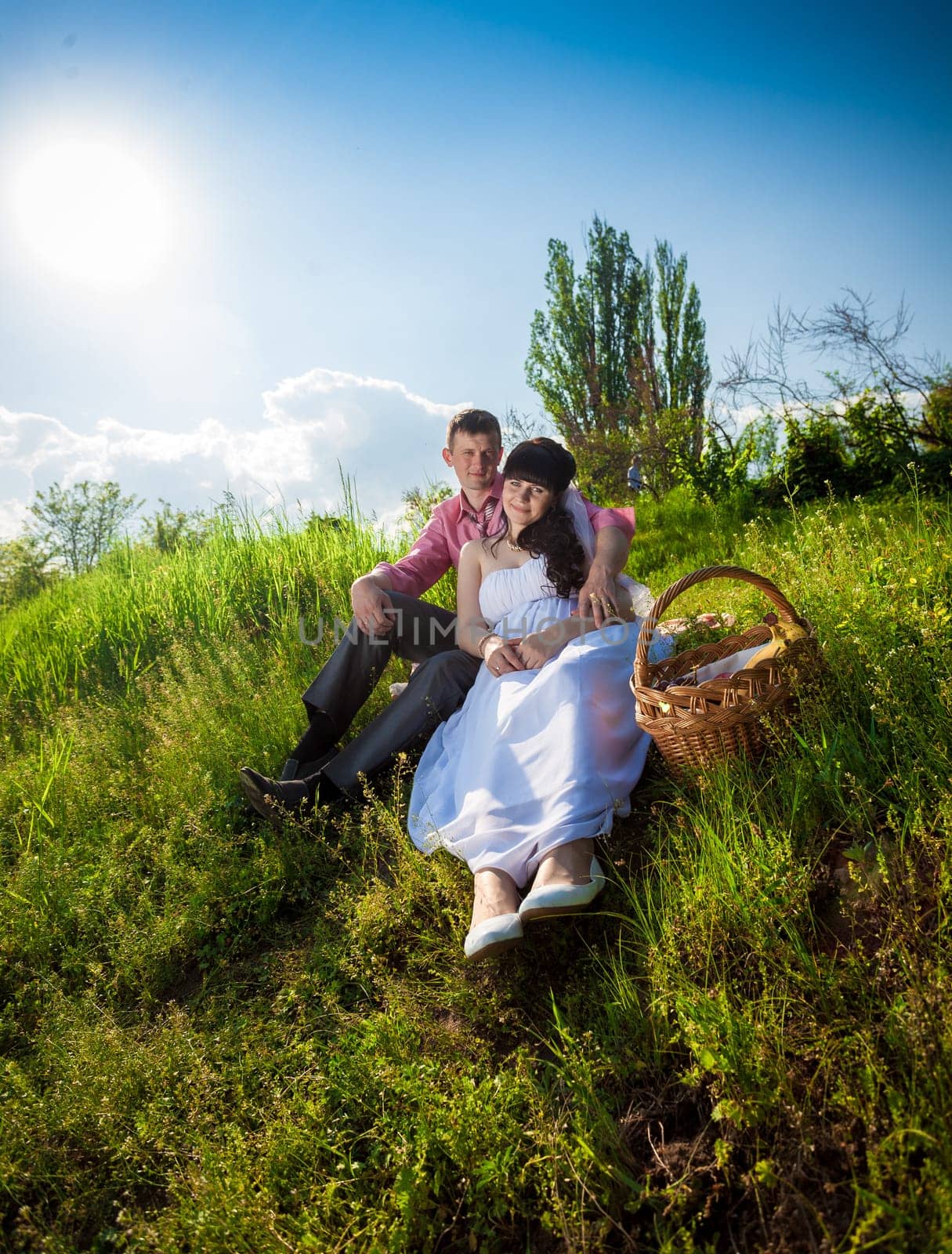 Happy just married couple having picnic at meadow