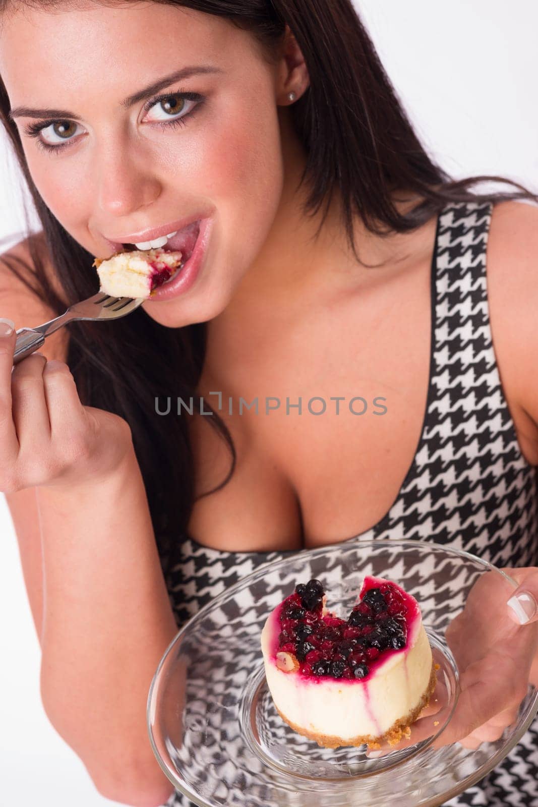 Beautiful woman smiles while eating cheesecake dessert