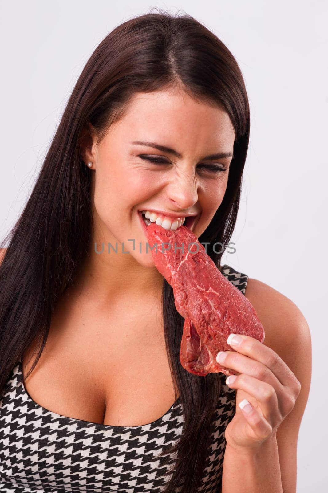 Woman bites into red steak meat