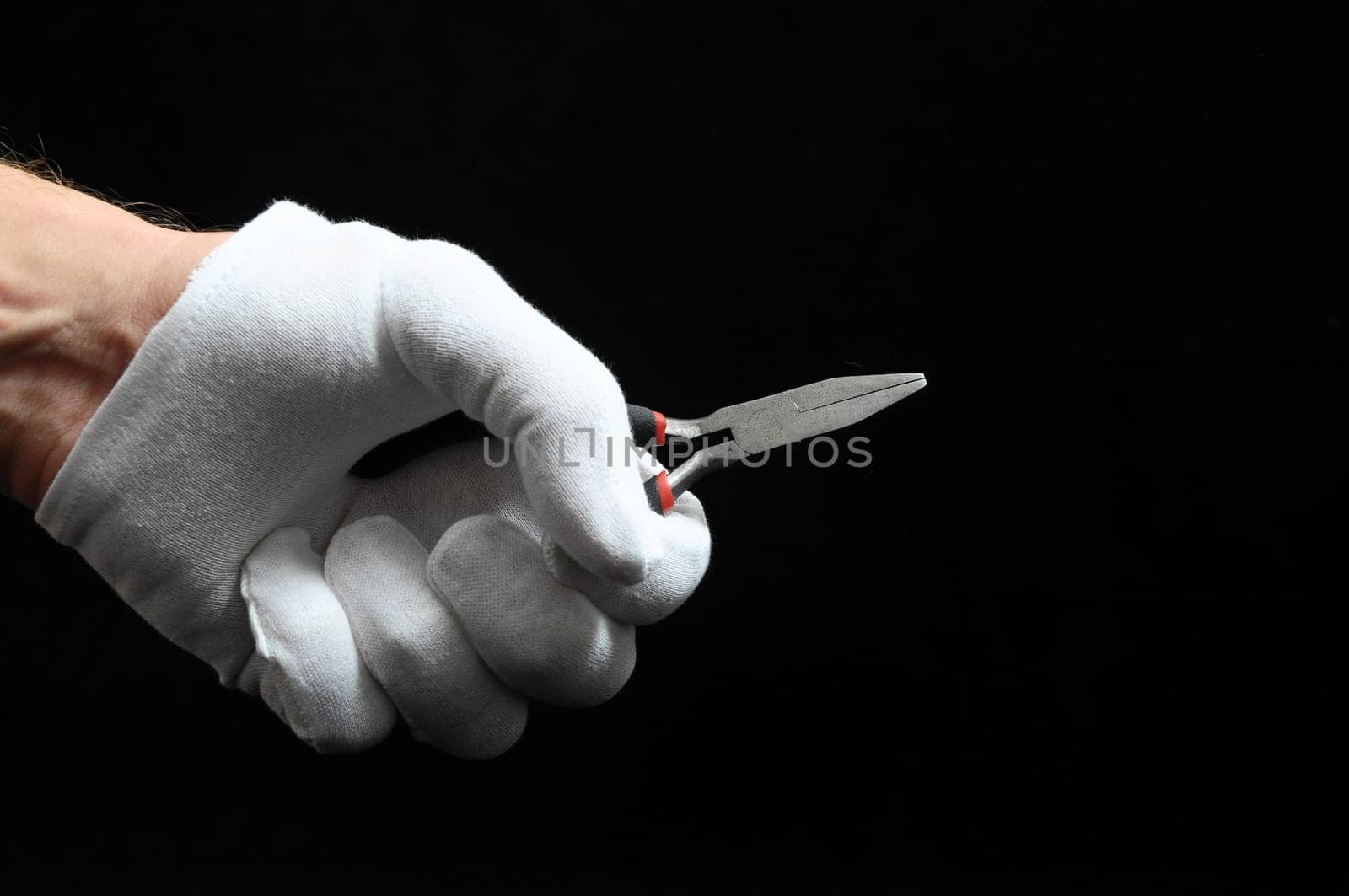 Pliers and a Hand on a Black Background