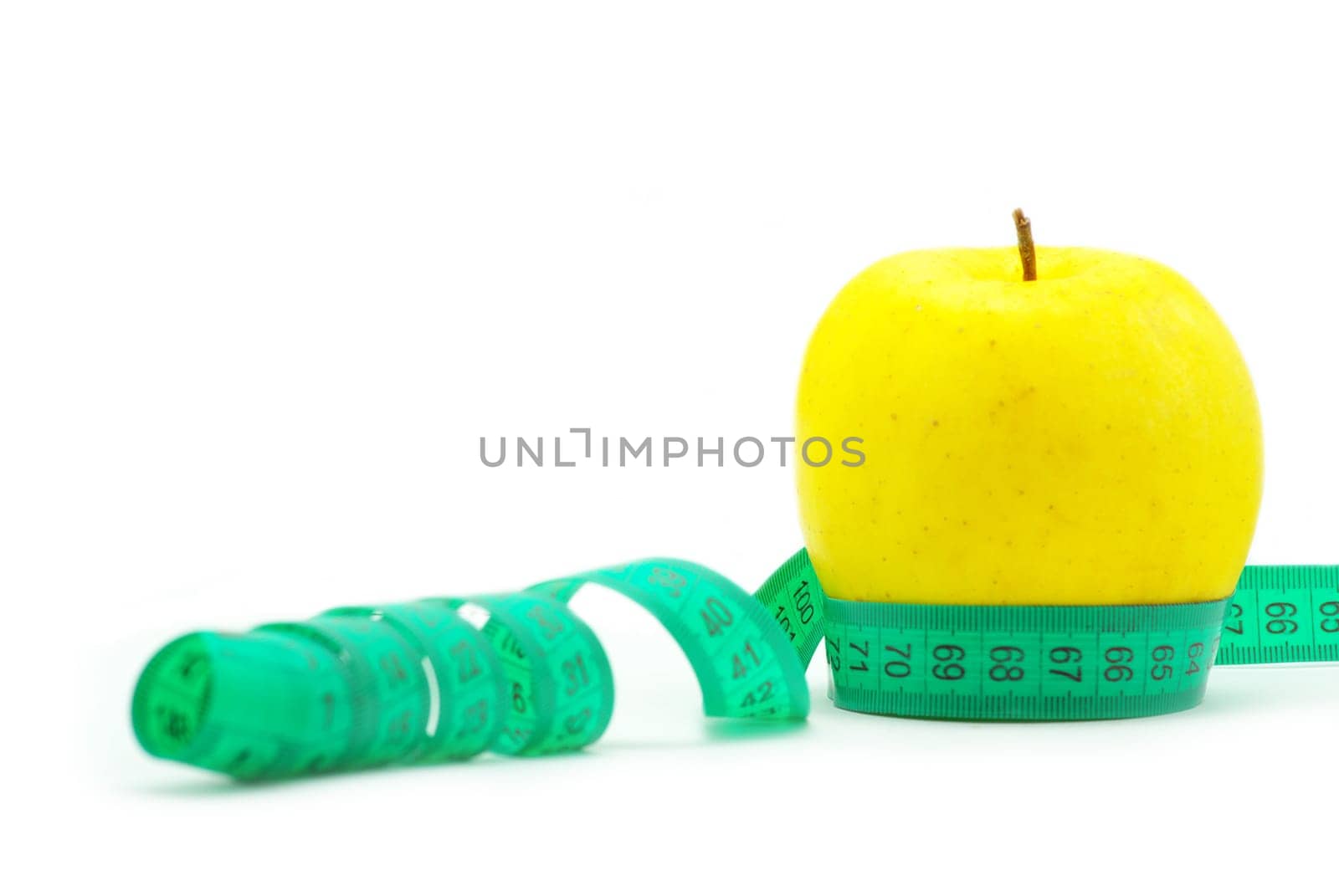yellow apple and measuring tape on white