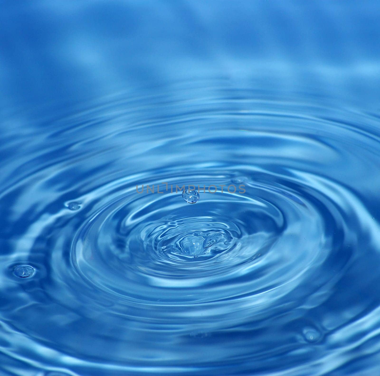 The round transparent drop of water falls downward