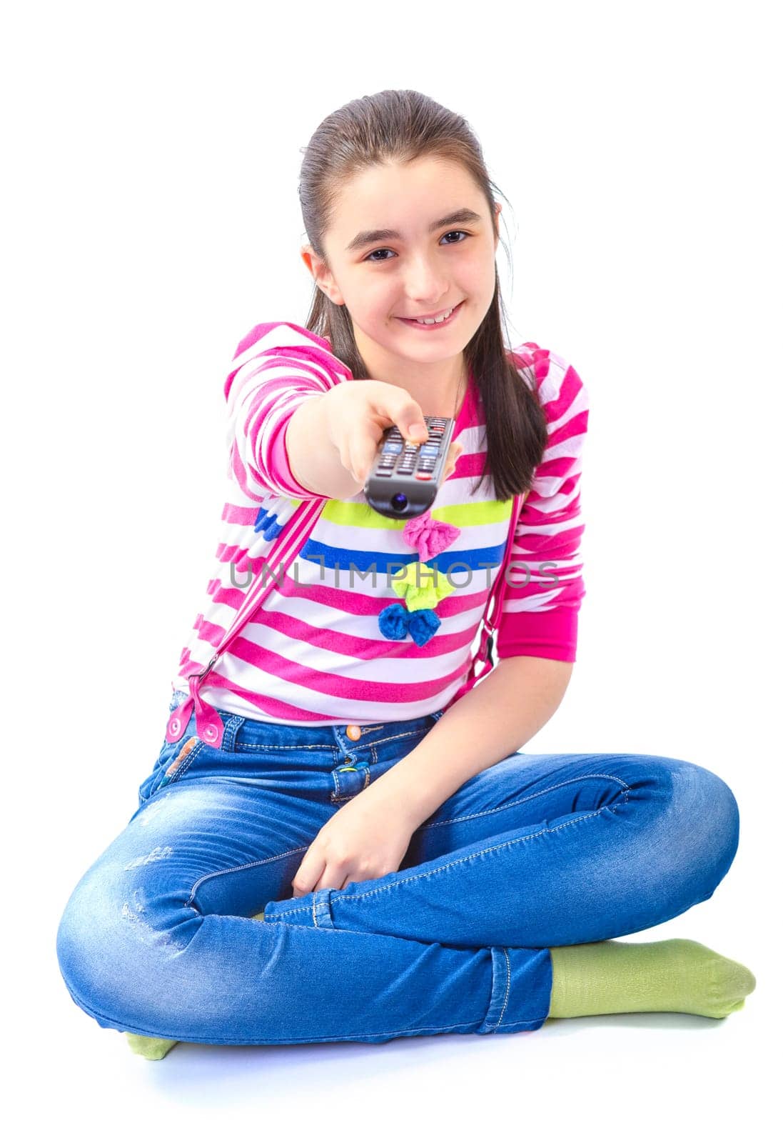 Little girl with remote control laying down and watching tv