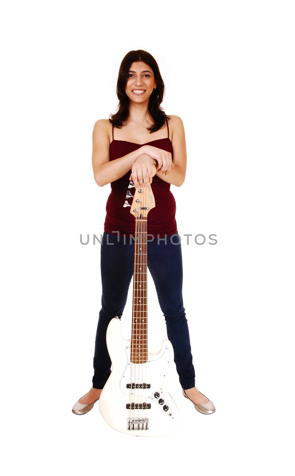A lovely young woman standing in jeans, isolated on white background,.holding her guitar and smiling..