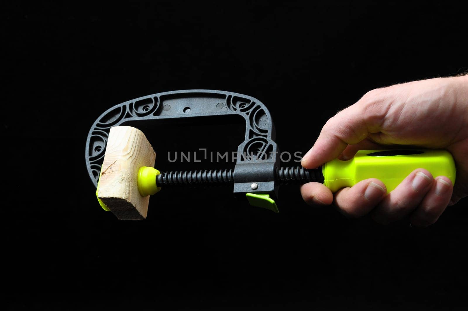 Pliers and a Hand on a Black Background