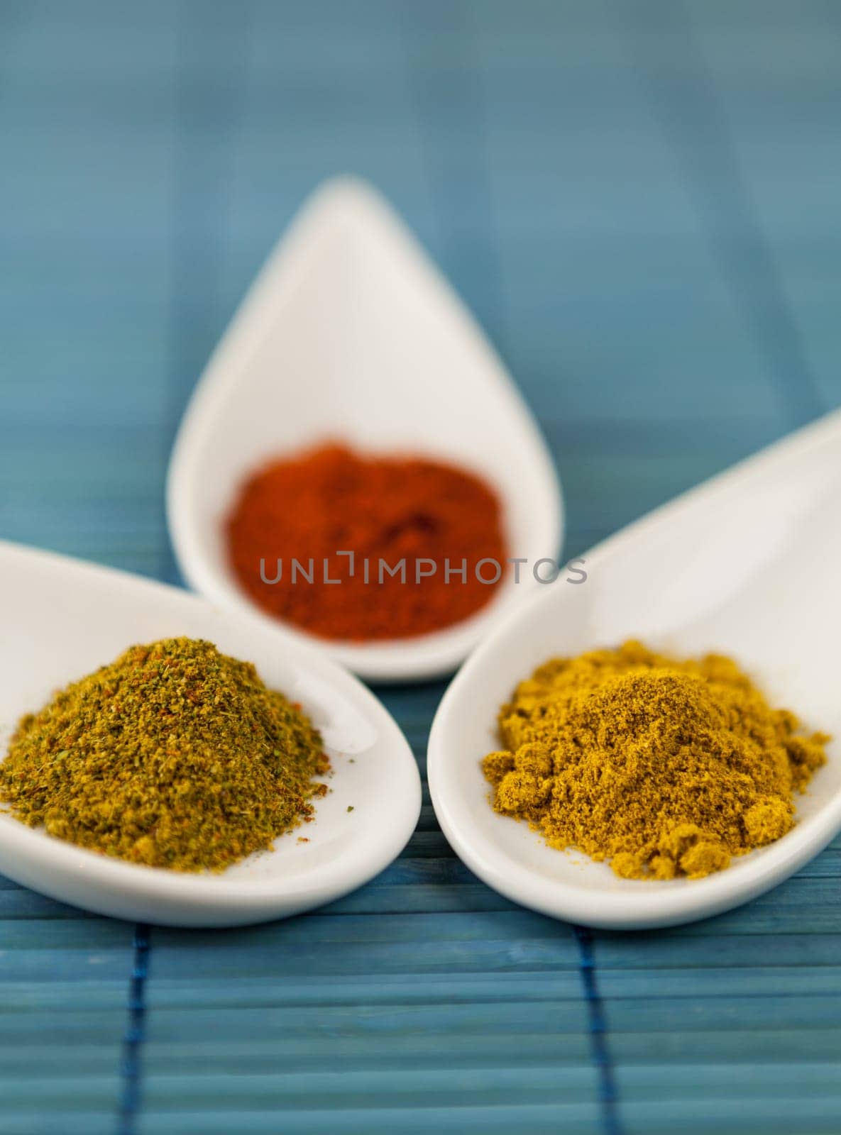 dried spices in porcelain bowls on a blue background