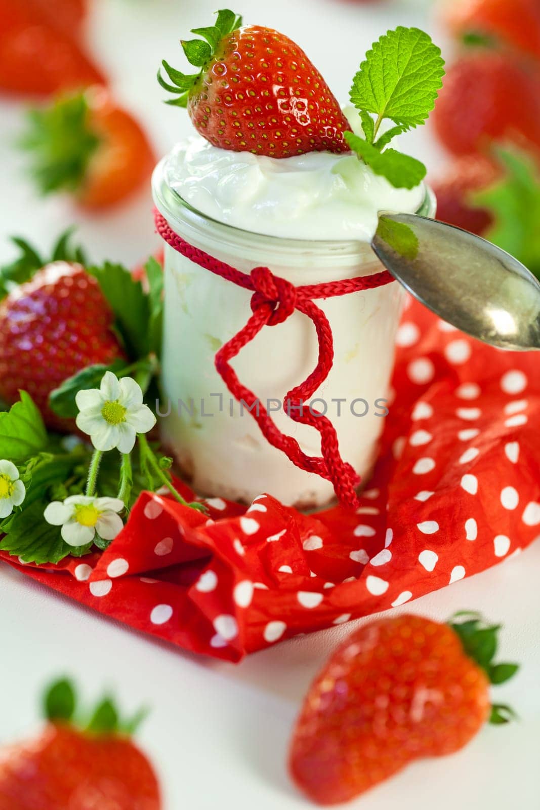 Fresh yoghurt with strawberries in a glass insulated on a white background