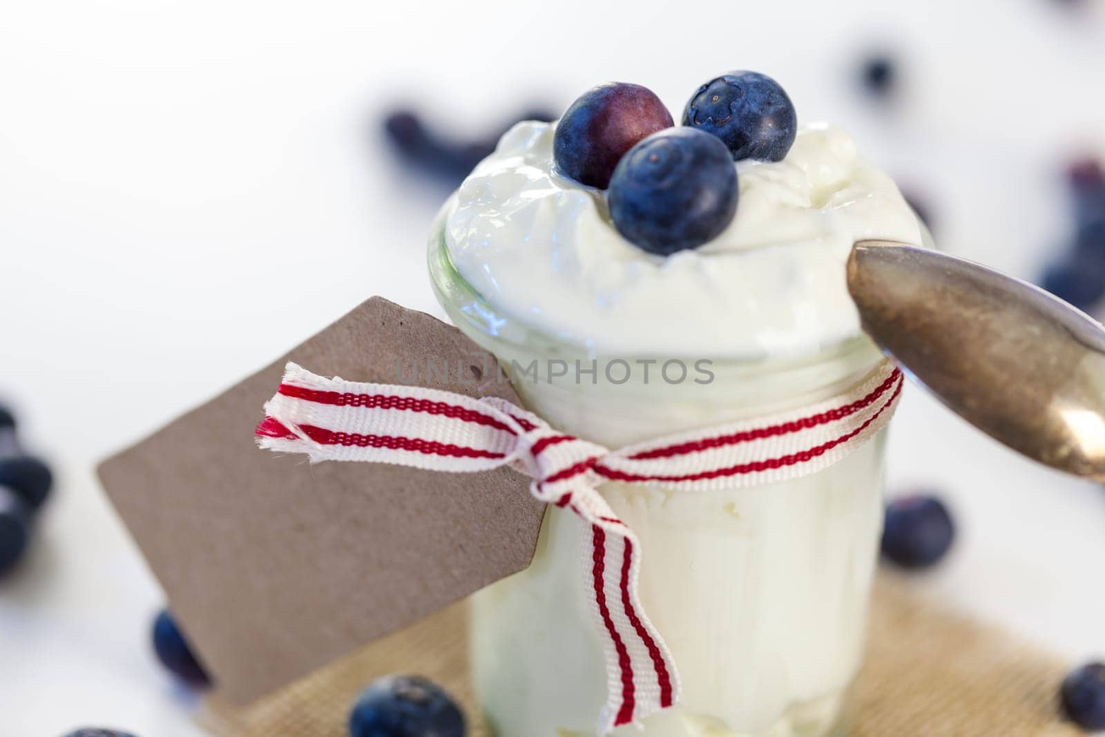 Glass with yoghurt and fresh blueberries blueberries for breakfast and for dessert