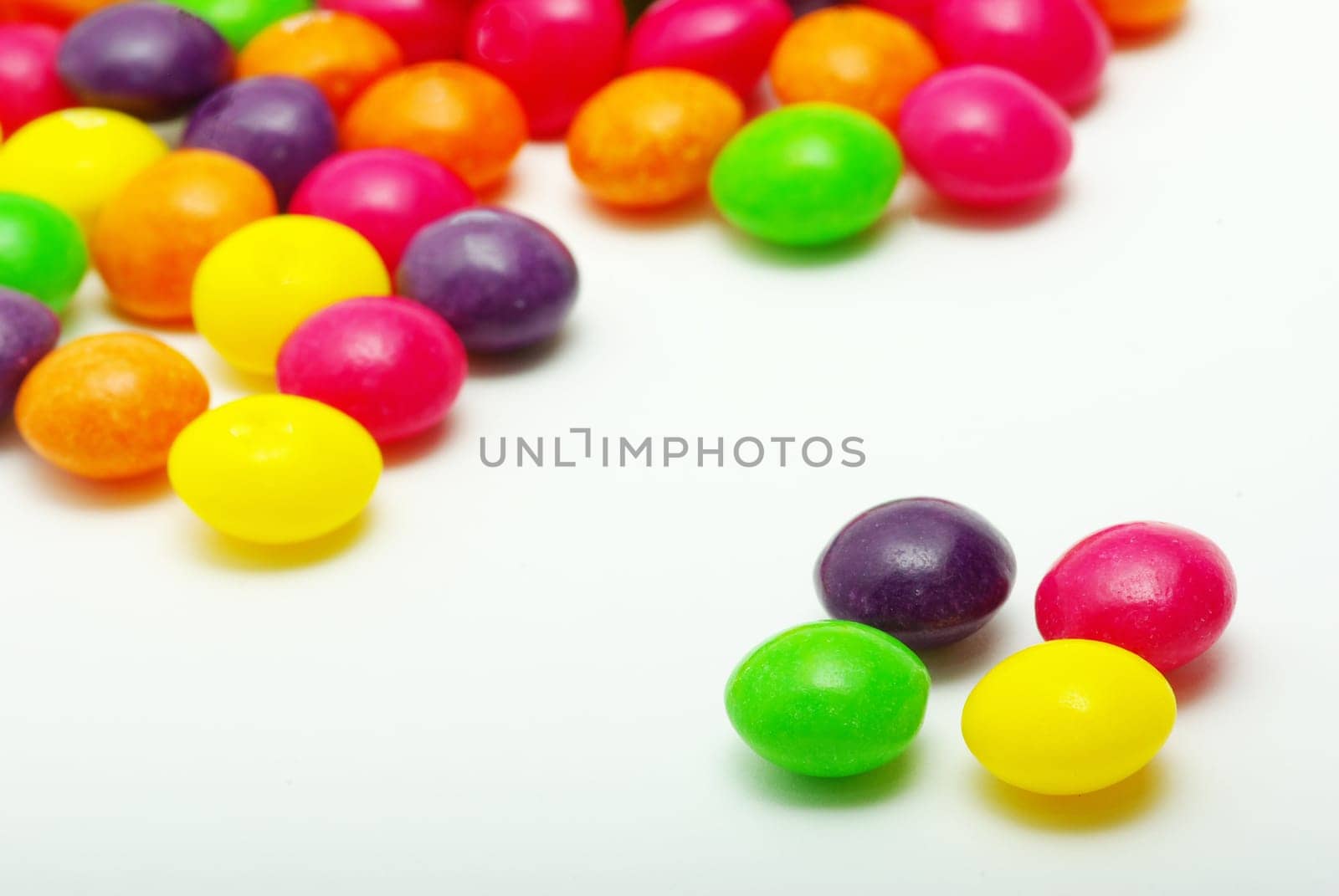 Set of sweet dragees of different color on white background