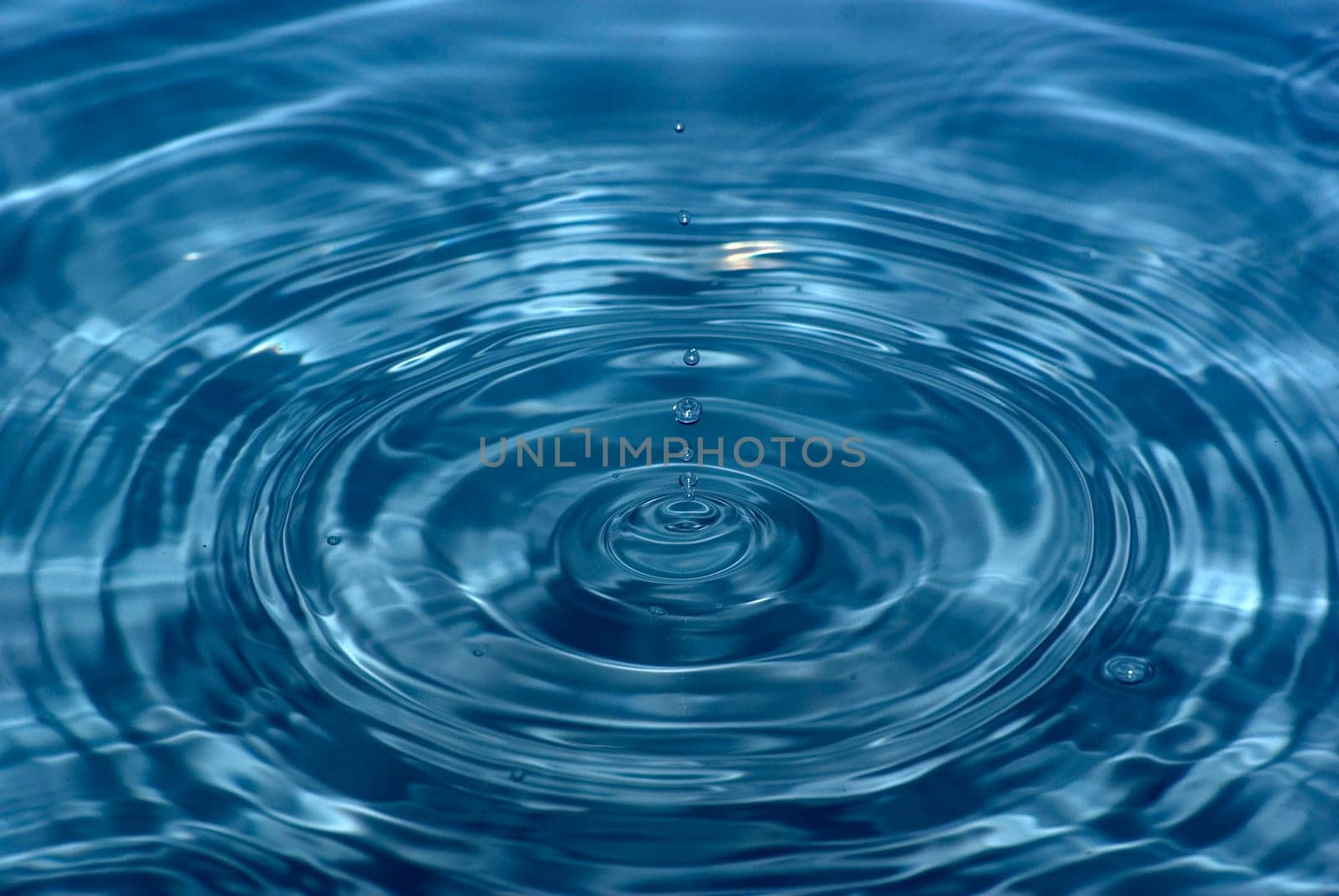 The round transparent drop of water falls downward