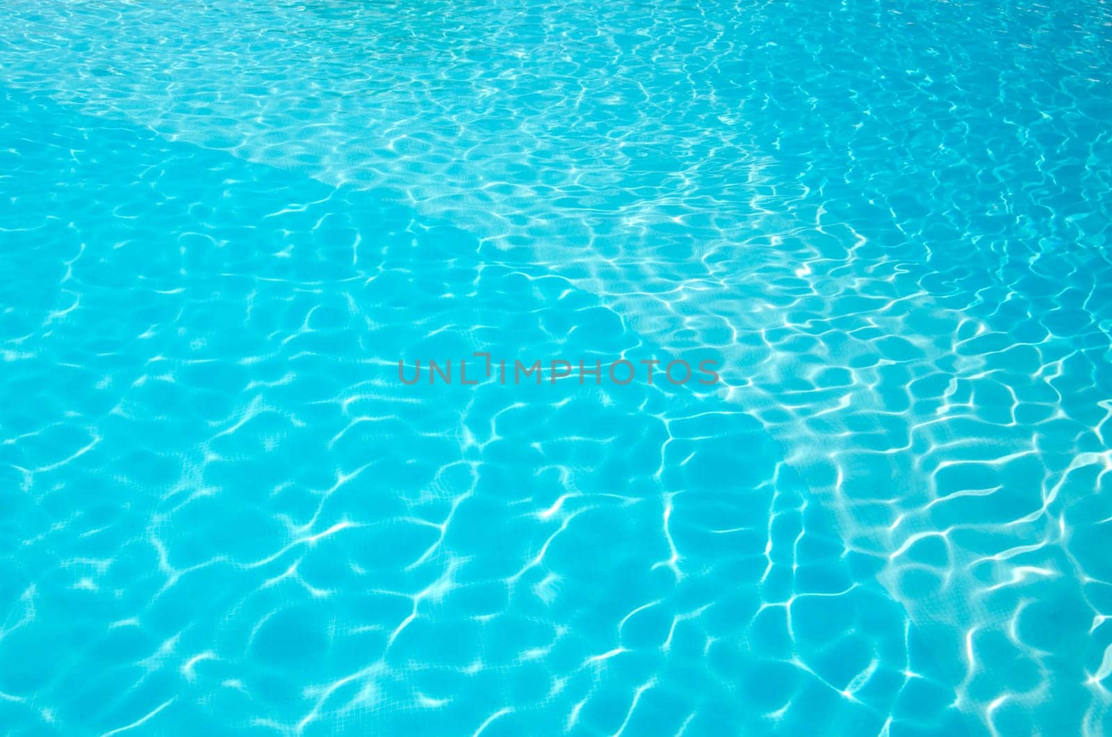 Blue pool water with sun reflections