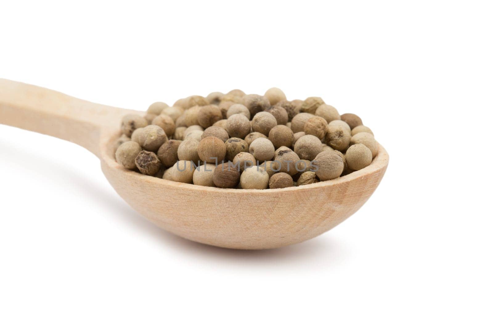 white peppercorns in wooden spoon