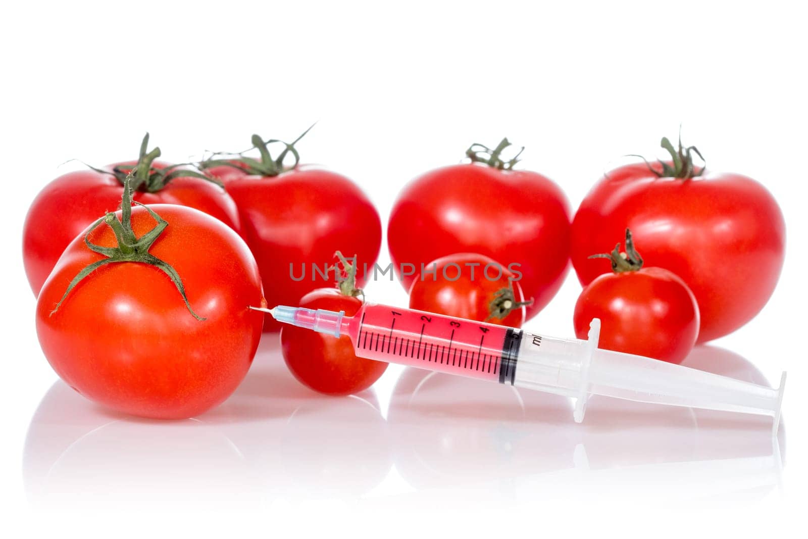 Injection into fresh red tomatoes, isolated on white background