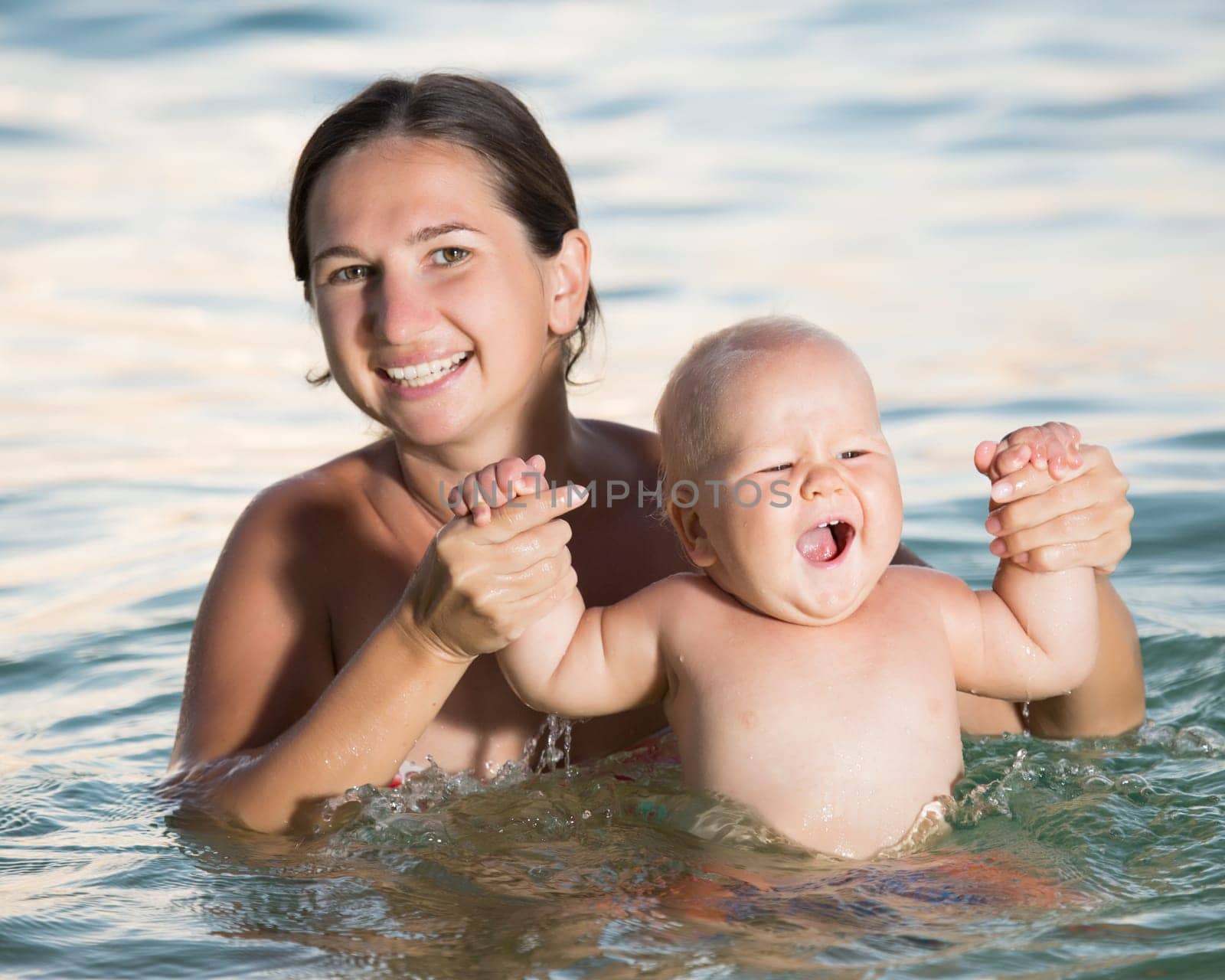 Baby and mother having fun time in the sea