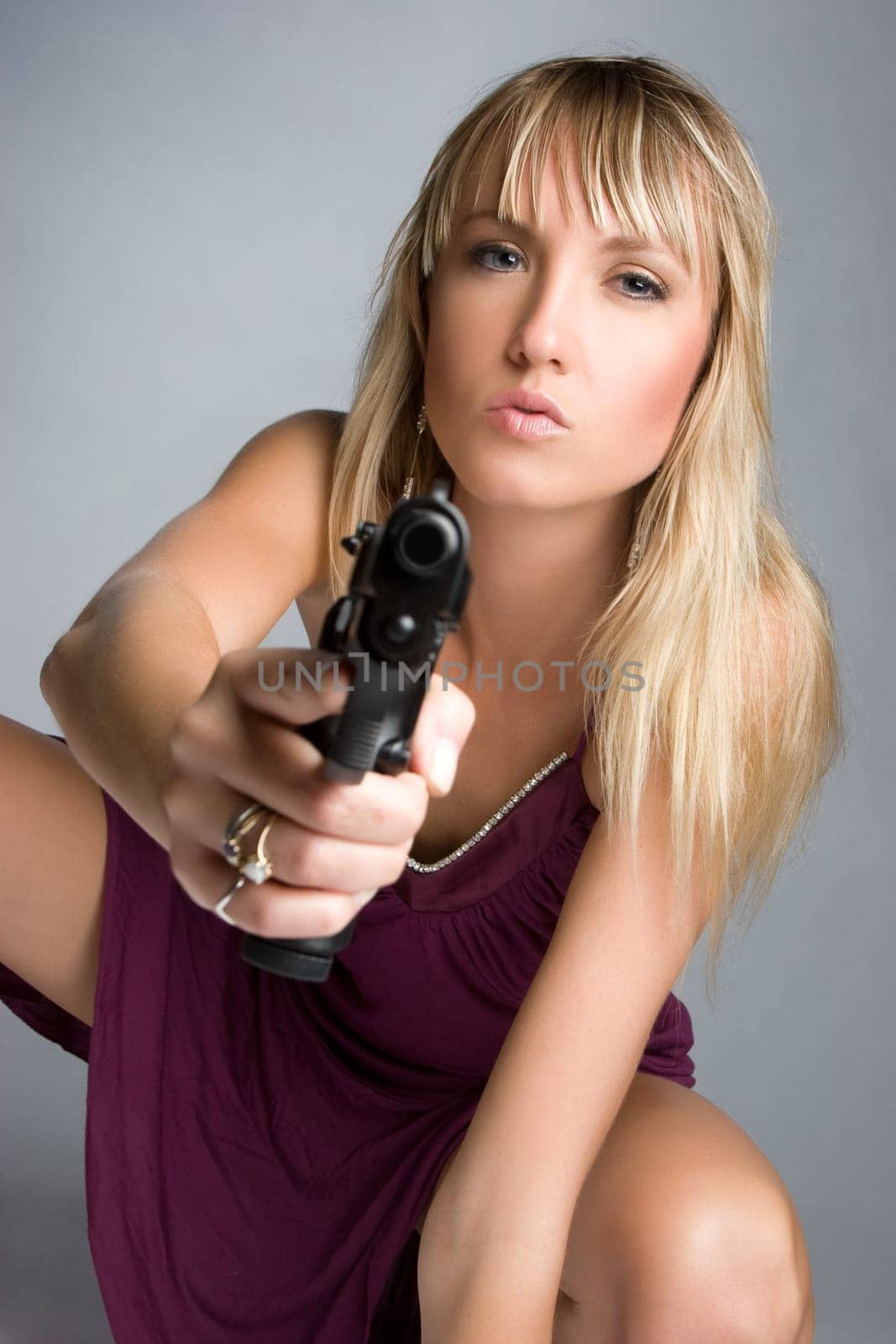 Sexy blond woman holding gun