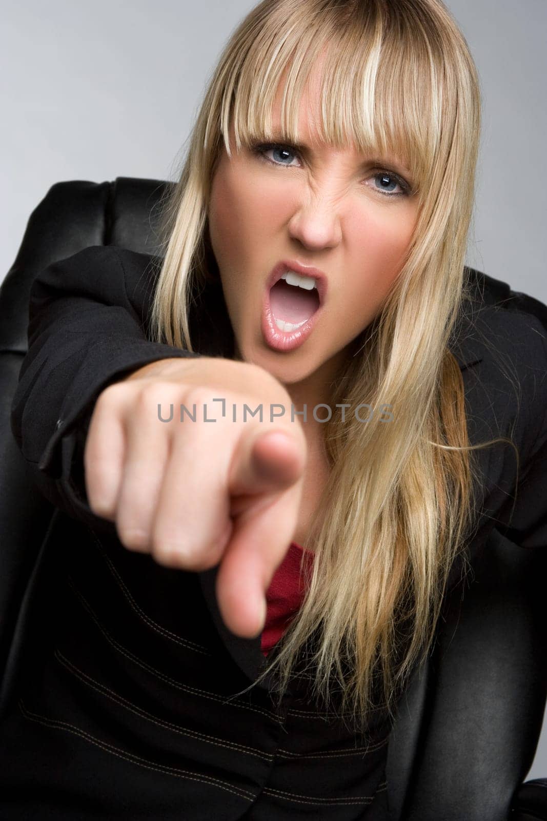 Angry blond business woman pointing yelling