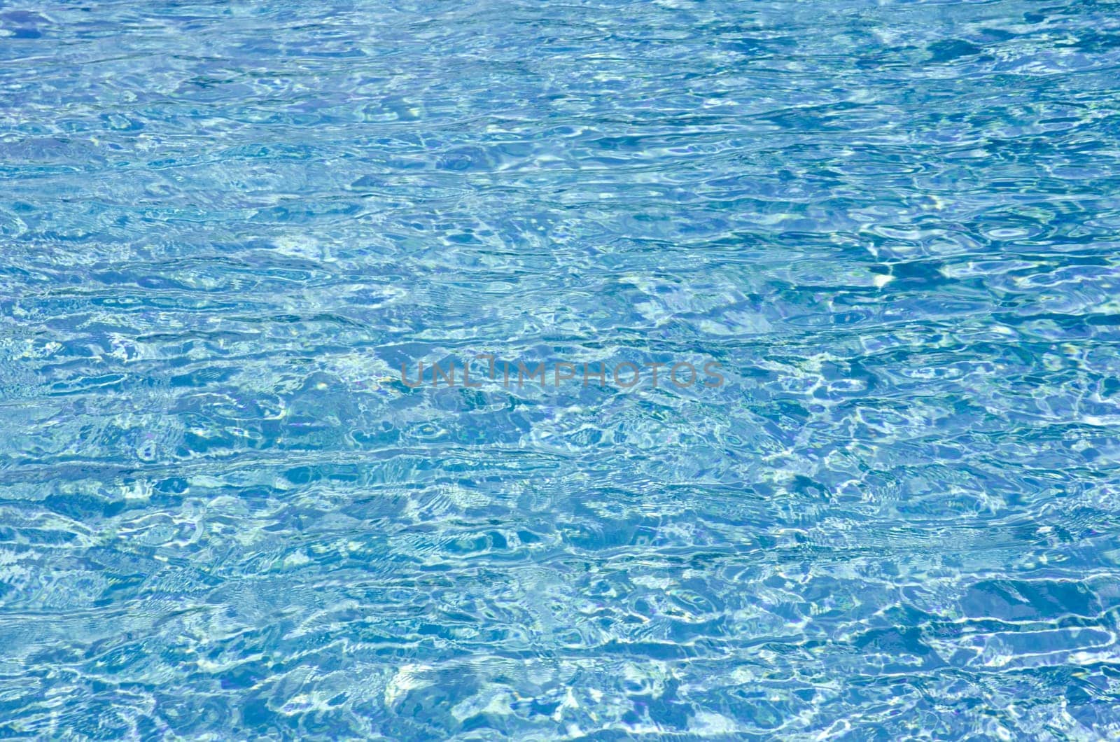 Blue pool water with sun reflections