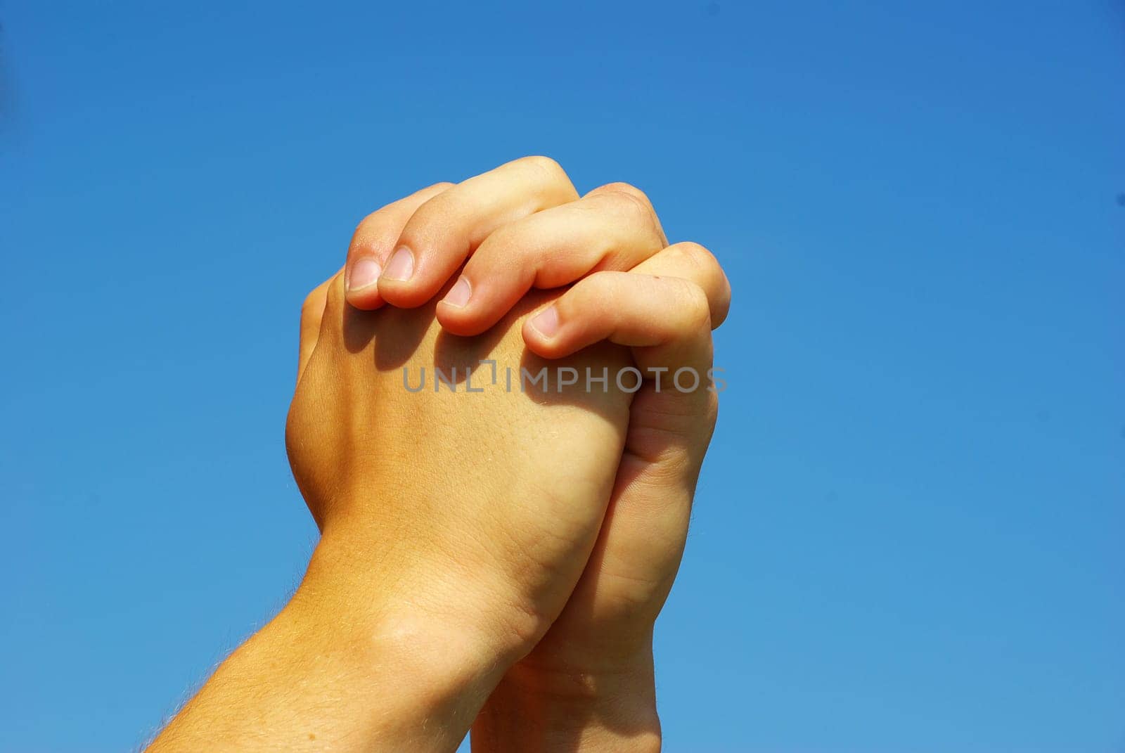 hands in prayer gesture on sky
