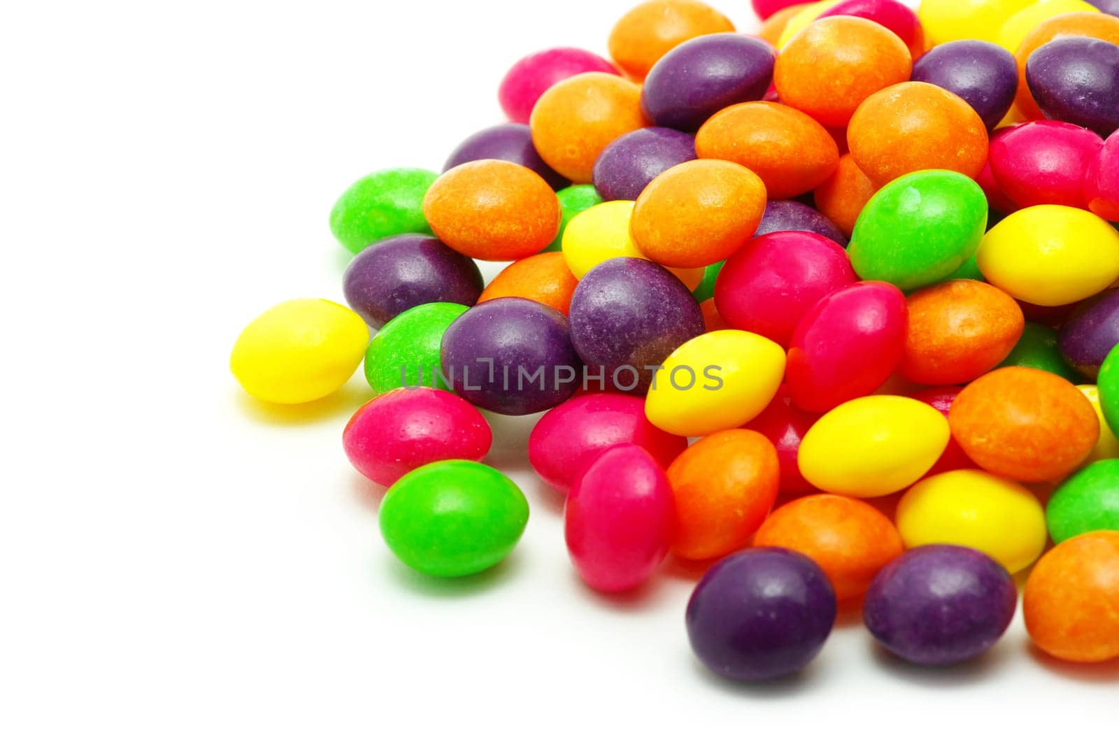 Set of sweet dragees of different color on white background