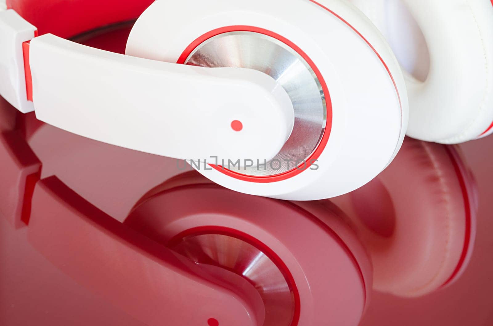 White red headphones on vinous clear polished mirrored surface