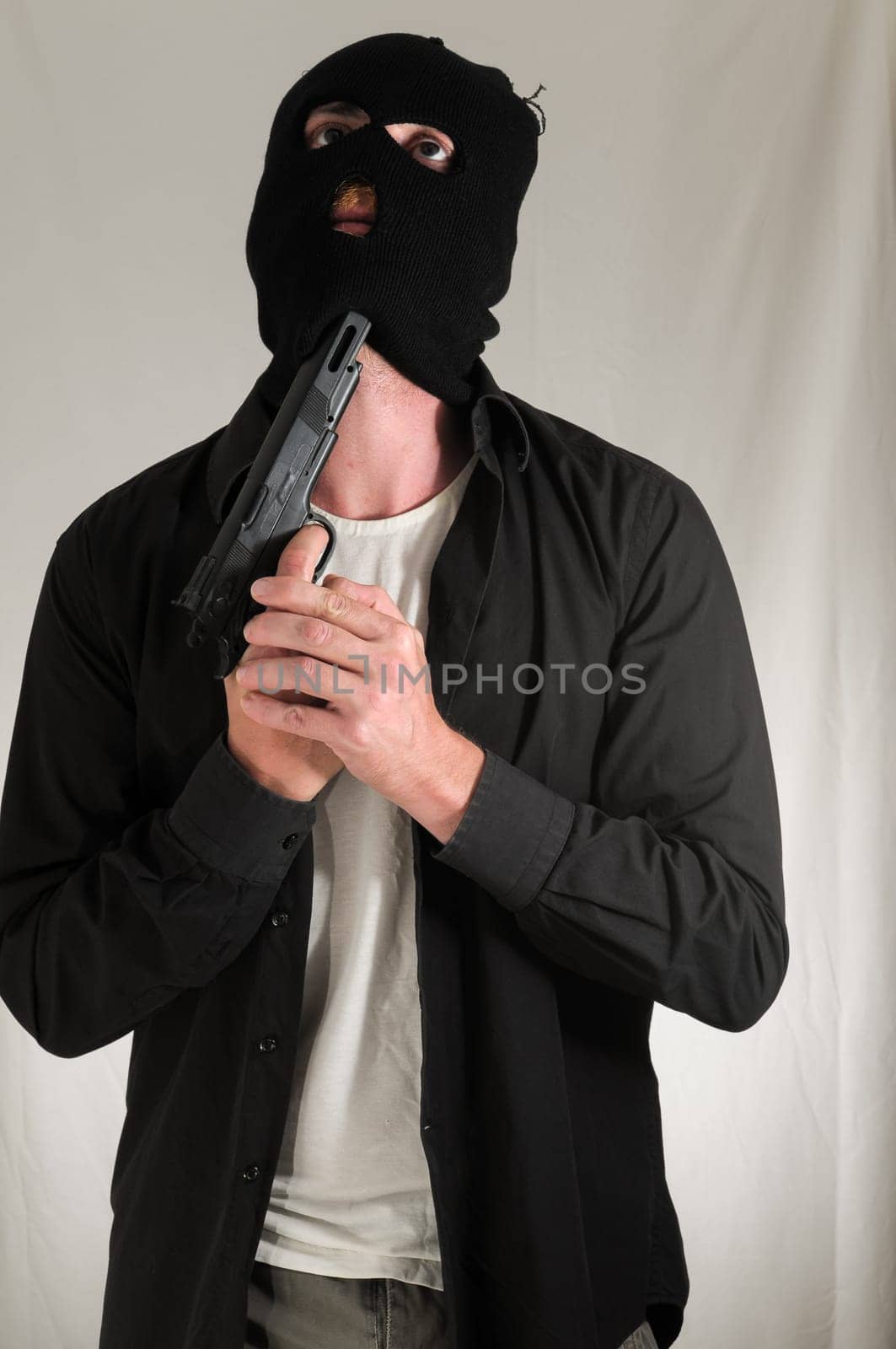 Black Dressed Young Man Holding a Pistol Gun