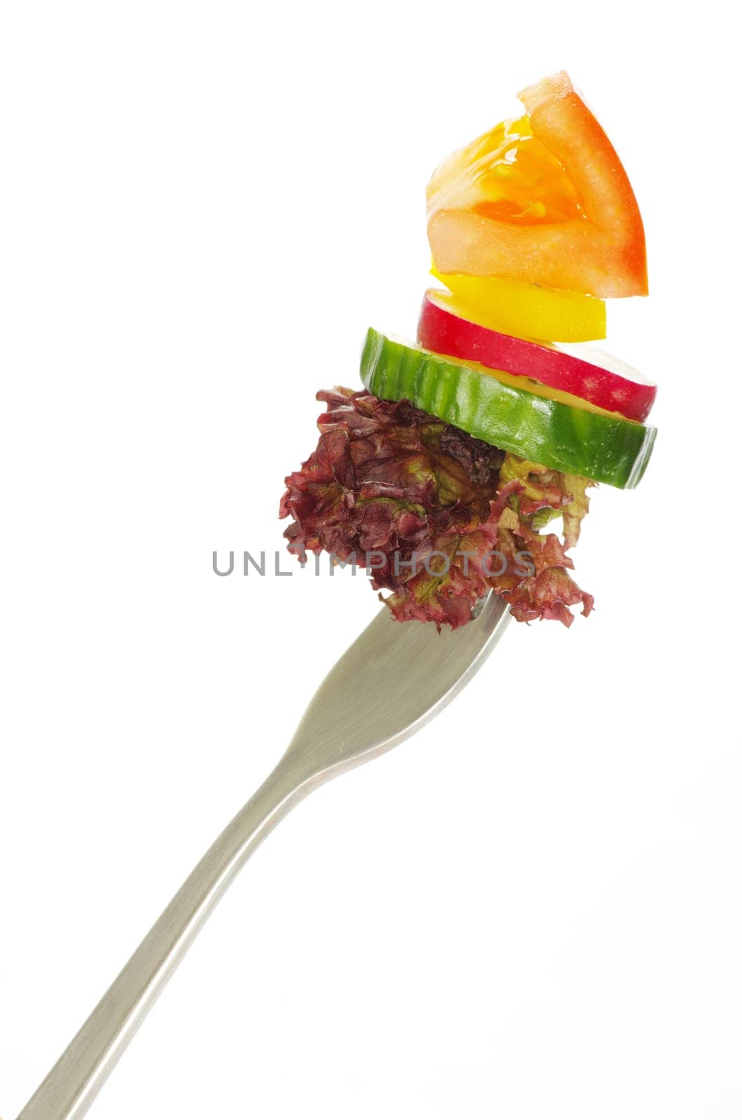 Fresh vegetables on a fork isolated on white background